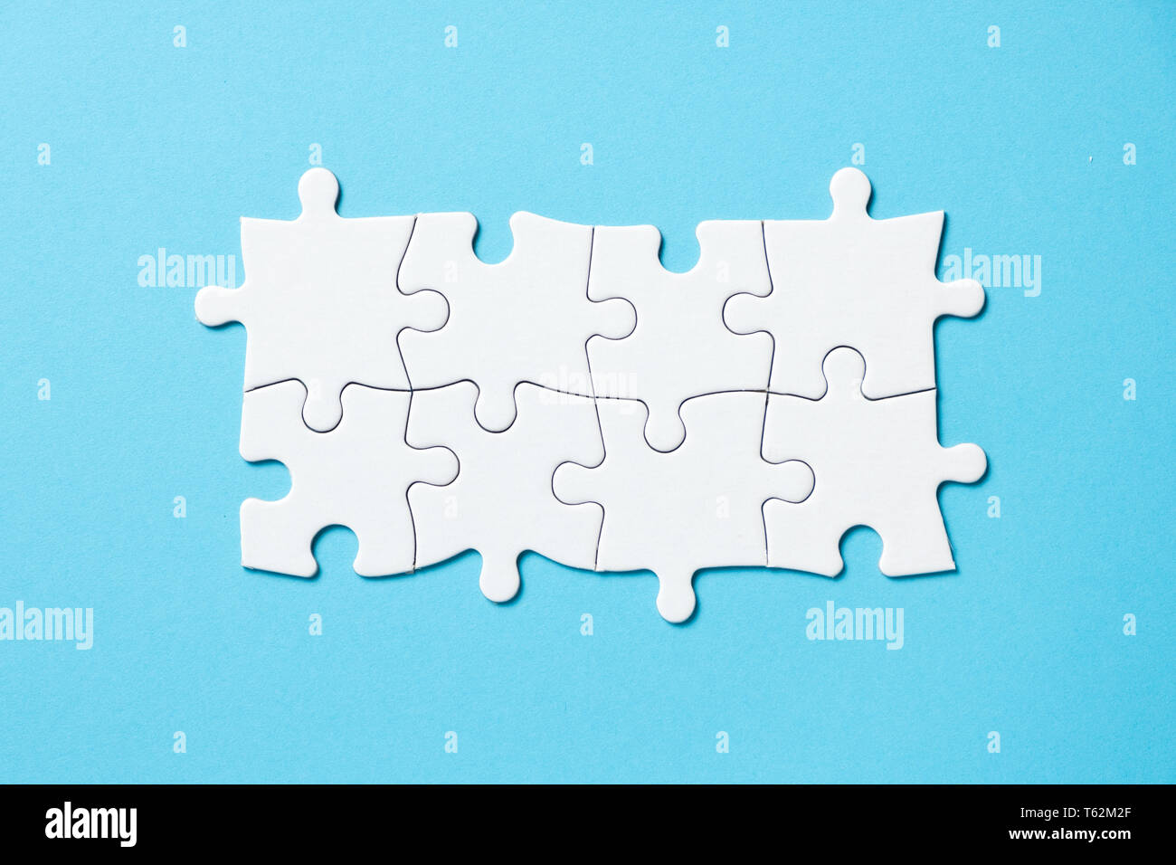 Eight pieces white jigsaw puzzle on blue background for business presentation Stock Photo