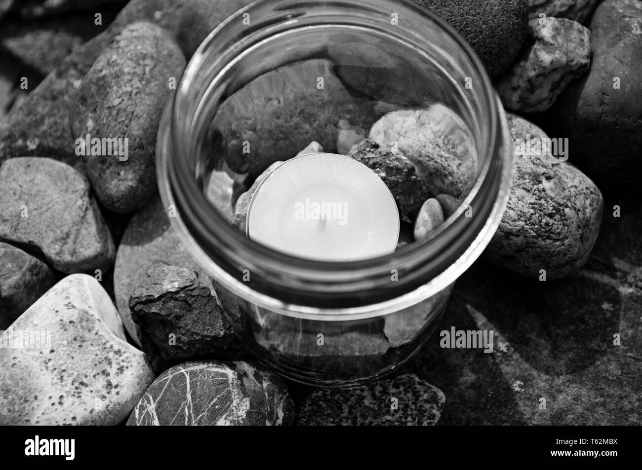 black and white tea light candle glass stones topview  by jziprian Stock Photo