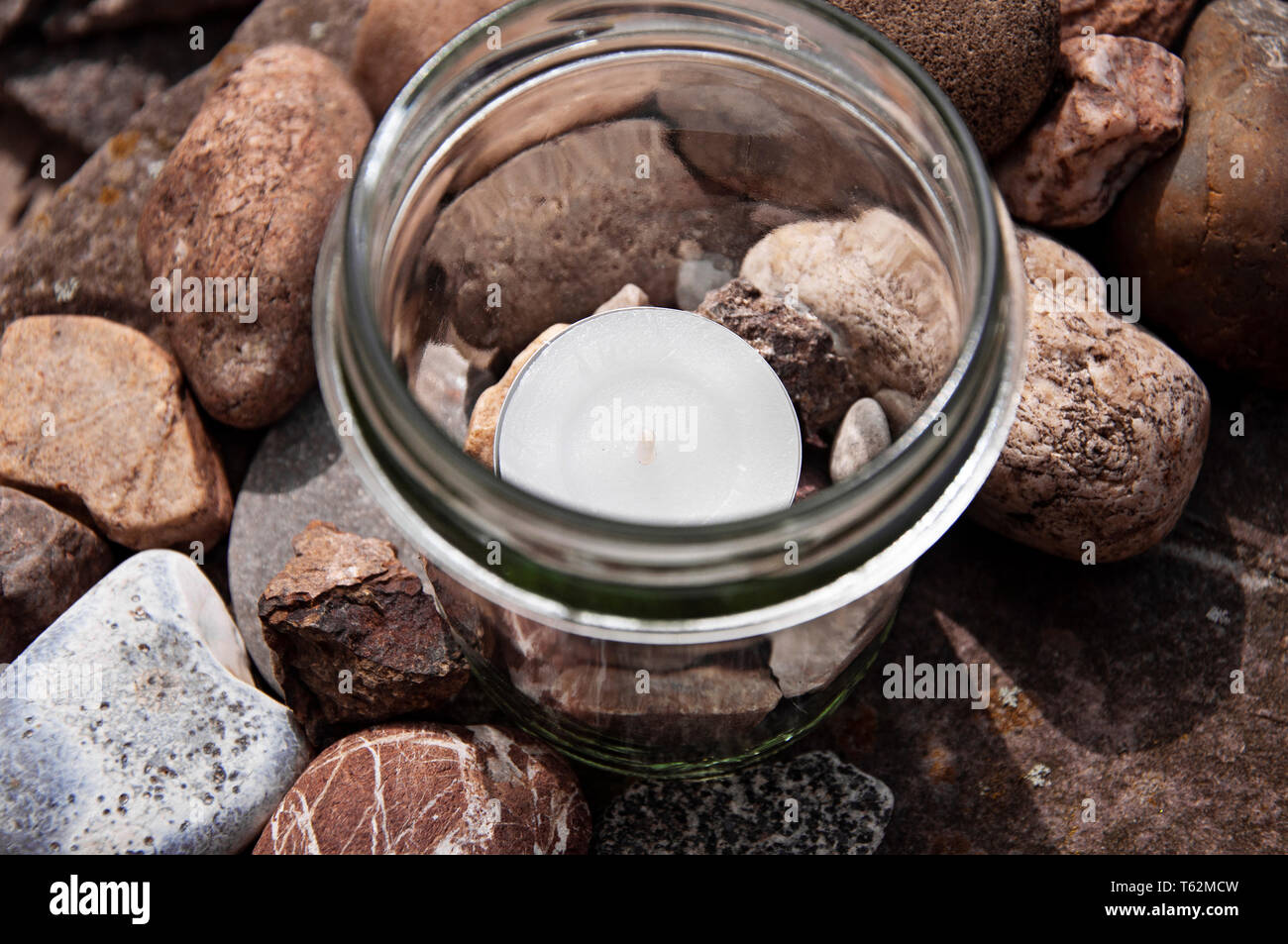 white tea light candle glass stones topview  by jziprian Stock Photo