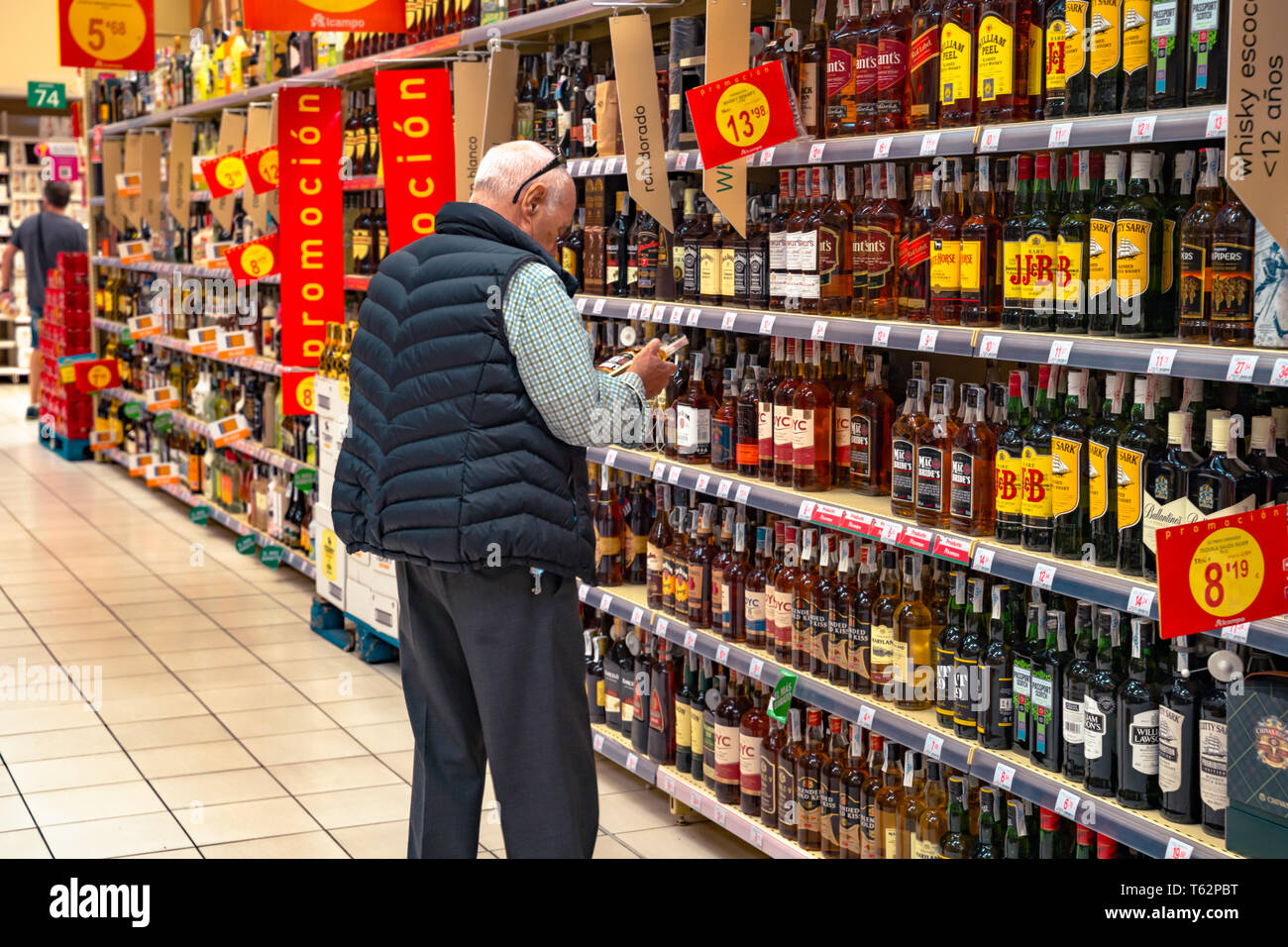 Valencia,Spain - April 27, 2019: Man choosing alcohol beverage. Hypermarket, spirits and wines department. Stock Photo