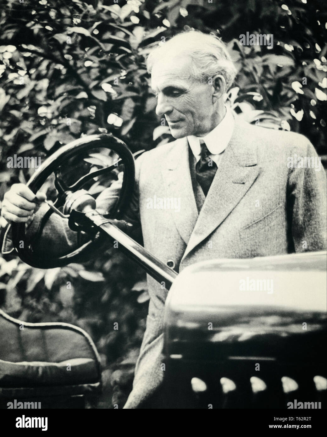 1920s PORTRAIT OF HENRY J. FORD HOLDING STEERING WHEEL - asp ap9672 ASP001 HARS OLD FASHIONED Stock Photo