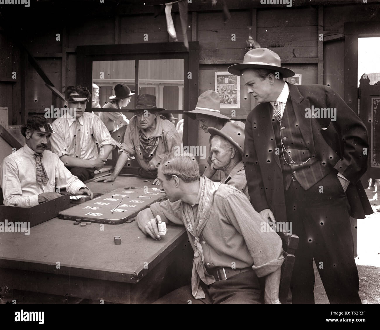1890s 1900s 1910s FARO CARD GAME MEN PLAYING GAMBLING IN OLD WILD WEST SALOON silent movie still uncorrected glass plate - asph106 ASP001 HARS WILD WEST LIFESTYLE ACTOR HISTORY STUDIO SHOT COPY SPACE HALF-LENGTH PERSONS DANGER MALES RISK WESTERN ENTERTAINMENT DEALER ACTING PLAYERS B&W MOVIES COWBOYS FREEDOM GAMBLING LUCK POKER TURN OF THE 20TH CENTURY CHOICE DRAMATIC EXCITEMENT LUCKY FILM STILLS IN OF SALOON FILM STILL UNLUCKY ACTORS DRAMA GAMBLE SILENT MOVIE GAMBLERS MOTION PICTURE PUBLICITY STILL STILLS MOVIE STILL BET BLACK AND WHITE CAUCASIAN ETHNICITY CHANCE OLD FASHIONED Stock Photo