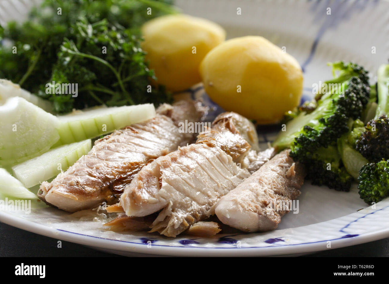 Mackerel fish dish with potatoes, broccoli, onions and parley. Fatty, oily fish is an excellent and healthy source of DHA and EPA, which are two key t Stock Photo