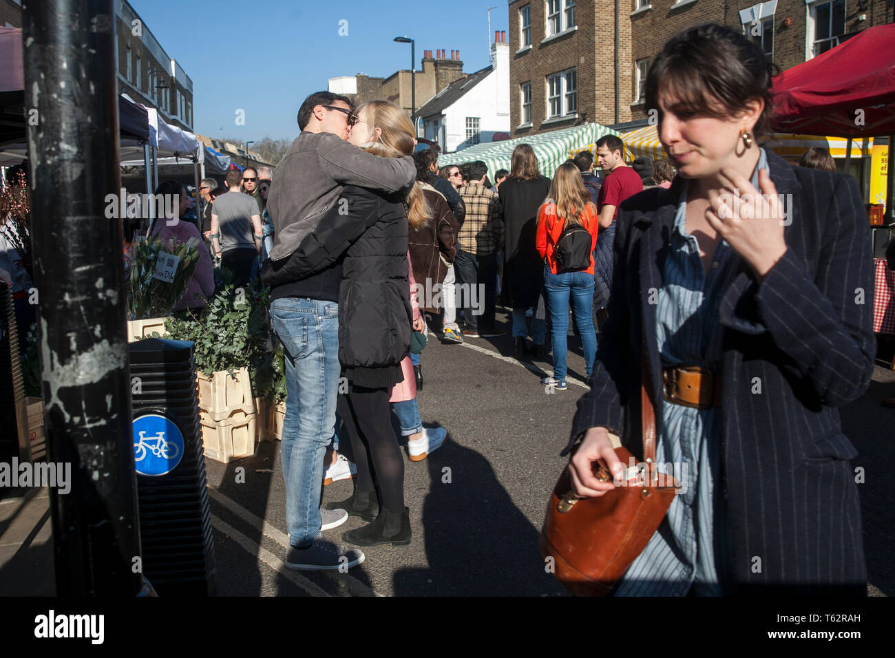 LONDON, UK - APRIL 17, 2019 People at the East London. Happy couple kisses on broadway market Stock Photo