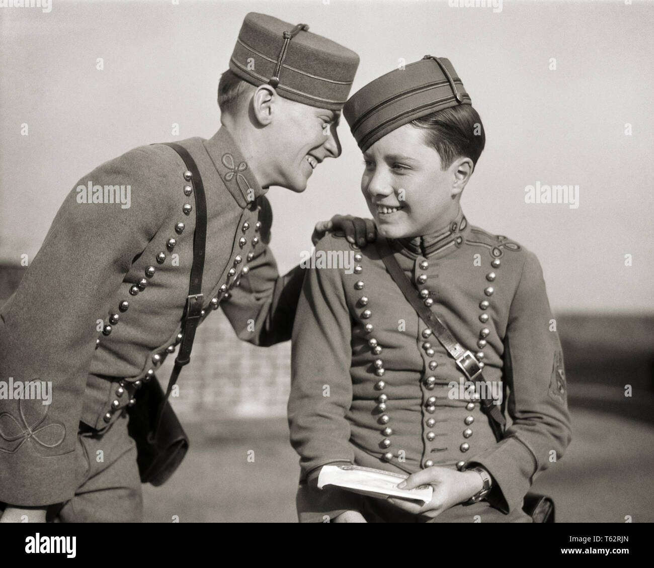 1920s 1930s TWO SMILING HOTEL BELLHOPS IN UNIFORM SHARING A SECRET - b3645 HAR001 HARS YOUNG ADULT TEAMWORK INFORMATION PLEASED JOY LIFESTYLE GOSSIP JOBS COPY SPACE FRIENDSHIP HALF-LENGTH PERSONS MALES TEENAGE BOY GOSSIPING B&W OCCUPATION HAPPINESS CHEERFUL KNOWLEDGE LABOR EMPLOYMENT OCCUPATIONS SMILES CONNECTION JOYFUL MESSENGER STYLISH TEENAGED BELLHOP EMPLOYEE COOPERATION JUVENILES PRE-TEEN PRE-TEEN BOY SECRETS TOGETHERNESS YOUNG ADULT MAN BLACK AND WHITE CAUCASIAN ETHNICITY HAR001 LABORING OLD FASHIONED Stock Photo