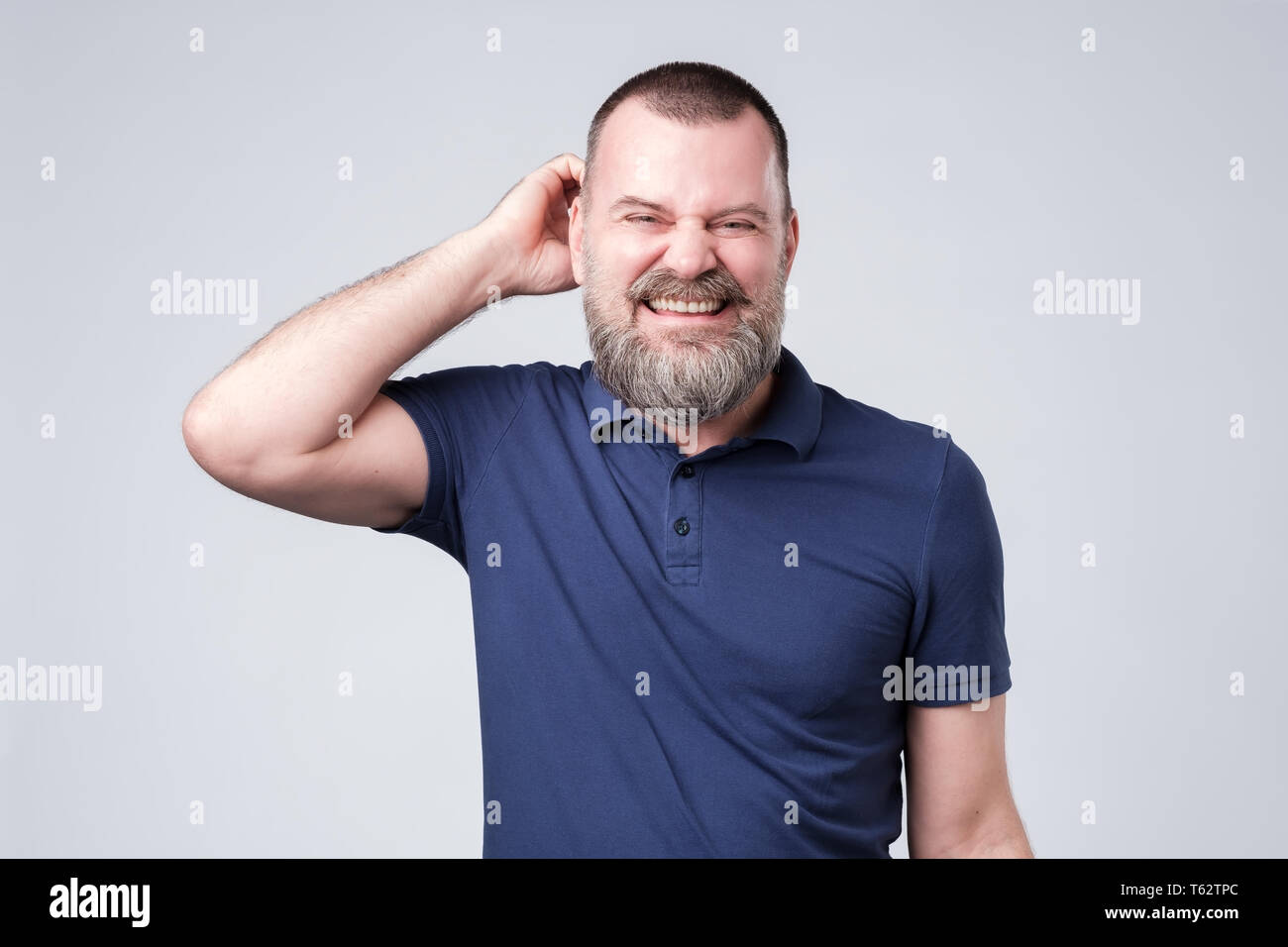man looking aside scratching head. I have no idea how it happened. Stock Photo