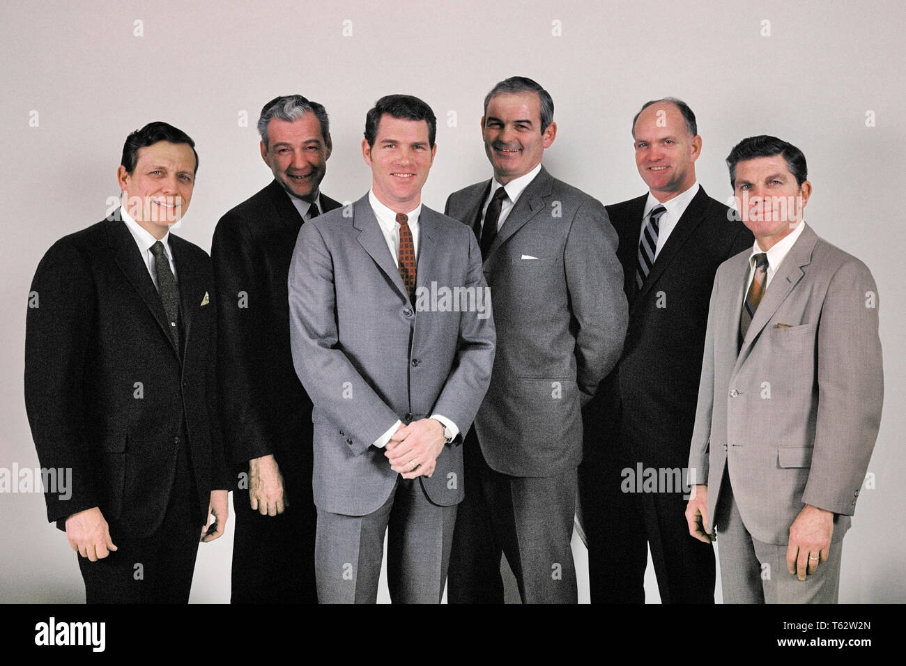 1960s SIX BUSINESSMEN EXECUTIVE GROUP ALL CAUCASIAN WEARING SUITS STANDING IN LINE SMILING LOOKING AT CAMERA  - kc3873 HAR001 HARS SATISFACTION STUDIO SHOT HEALTHINESS 6 MANAGER COPY SPACE FRIENDSHIP HALF-LENGTH PERSONS MALES SIX CORPORATE CONFIDENCE EXECUTIVES EXPRESSIONS MIDDLE-AGED MIDDLE-AGED MAN EYE CONTACT SUCCESS SUIT AND TIE SELLING HAPPINESS CHEERFUL STRENGTH STYLES POWERFUL PRIDE AUTHORITY OCCUPATIONS SMILES BOARD OF DIRECTORS BOSSES CONNECTION JOYFUL STYLISH VARIOUS FASHIONS MANAGERS MID-ADULT MID-ADULT MAN SALESMEN TOGETHERNESS CAUCASIAN ETHNICITY HAR001 OLD FASHIONED Stock Photo