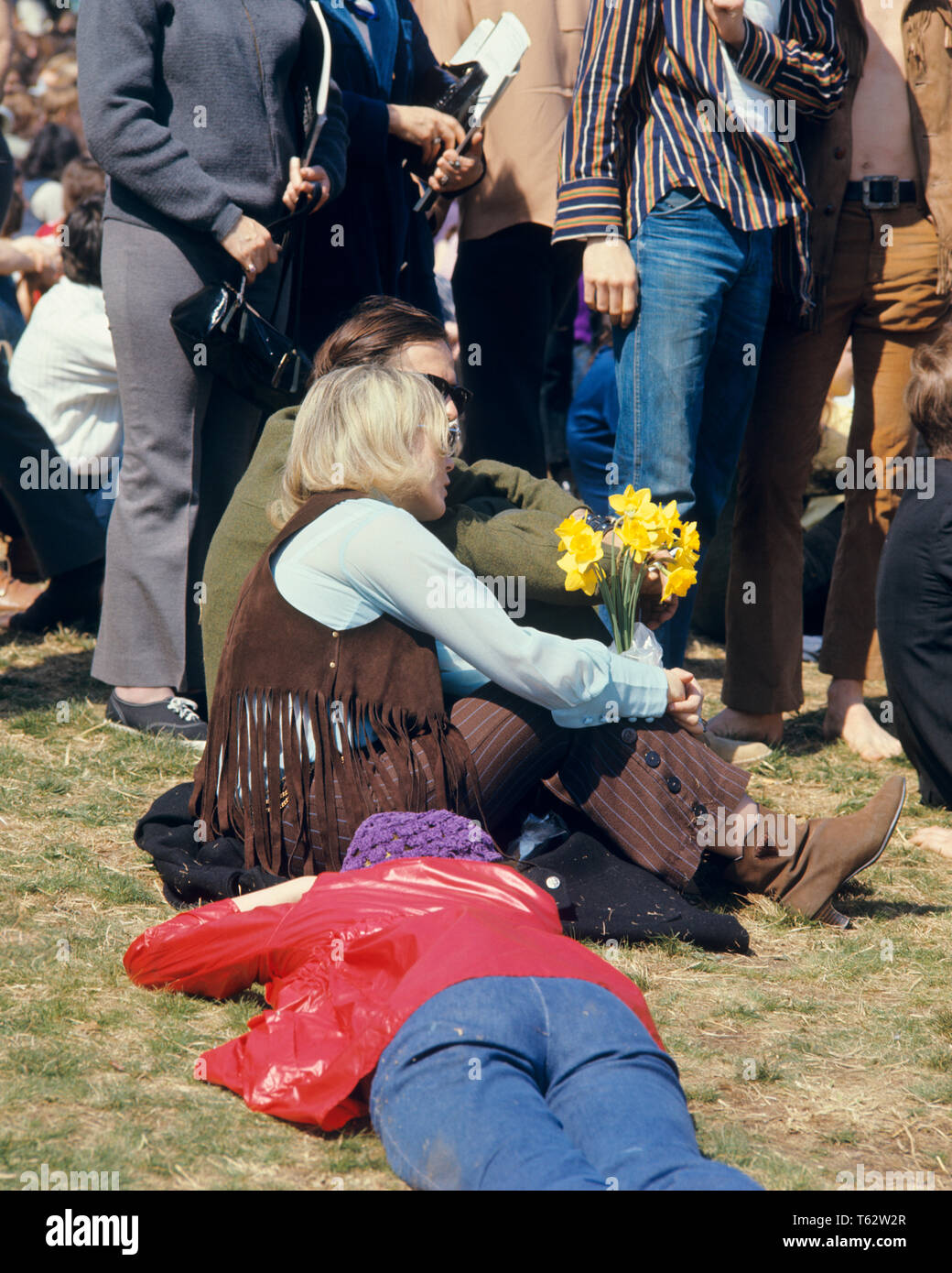 1960s BLONDE WOMAN IN FRINGED VEST HOLDING YELLOW DAFFODILS AMIDST CROWD 1969 PEACE RALLY FAIRMONT PARK PHILADELPHIA PA USA - kc4417 HAR001 HARS CELEBRATION FEMALES UNITED STATES FULL-LENGTH LADIES PERSONS INSPIRATION UNITED STATES OF AMERICA CARING SERENITY SPIRITUALITY VEST STRENGTH STYLES STRATEGY EXTERIOR PA POWERFUL IN OF DAFFODILS DEMONSTRATION POLITICS CONNECTION CONCEPTUAL FAIRMONT PARK STYLISH SUPPORT MOCCASINS ANONYMOUS 1969 COOPERATION FASHIONS FRINGED MIDST TOGETHERNESS YOUNG ADULT WOMAN CAUCASIAN ETHNICITY COUNTERCULTURE HAR001 OLD FASHIONED Stock Photo
