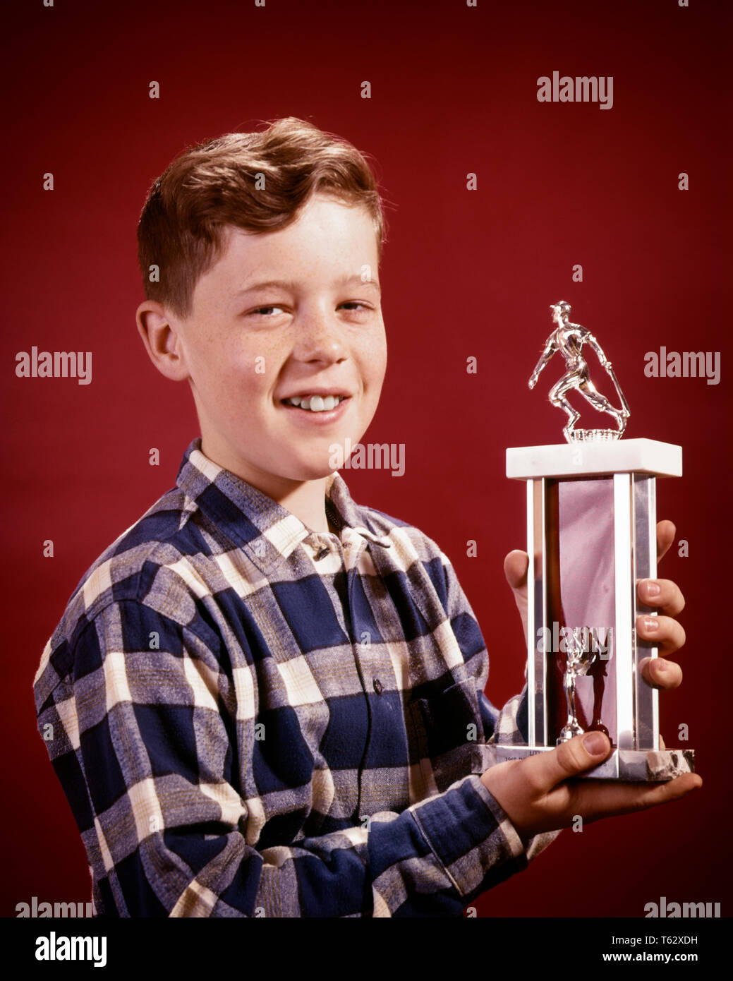 1960s SMILING BOY HOLDING LITTLE LEAGUE BASEBALL TROPHY LOOKING AT CAMERA - kj3660 HAR001 HARS LIFESTYLE SATISFACTION CELEBRATION PROUD STUDIO SHOT COPY SPACE TROPHY WINNER INSPIRATION MALES PLAID CONFIDENCE EXPRESSIONS AWARD EYE CONTACT HEAD AND SHOULDERS CHEERFUL VICTORY EXCITEMENT PRIZE RECREATION PRIDE PROUDLY SMILES JOYFUL BALL GAME BALL SPORT JUVENILES PRE-TEEN PRE-TEEN BOY BASEBALL BAT CAUCASIAN ETHNICITY HAR001 OLD FASHIONED Stock Photo