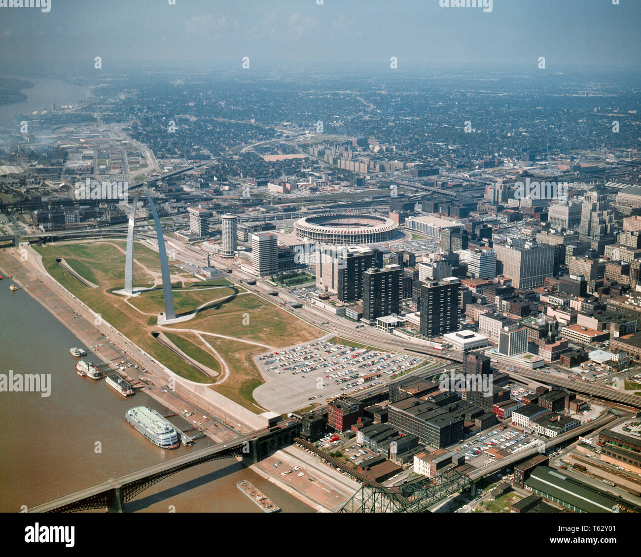 1960s AERIAL ST. LOUIS MISSOURI STADIUM DOWNTOWN ARCH GATEWAY MISSISSIPPI RIVER LOOKING NORTH TO SUBURBS - kr12926 KRU001 HARS MISSISSIPPI RIVER MO OLD FASHIONED ST. LOUIS Stock Photo