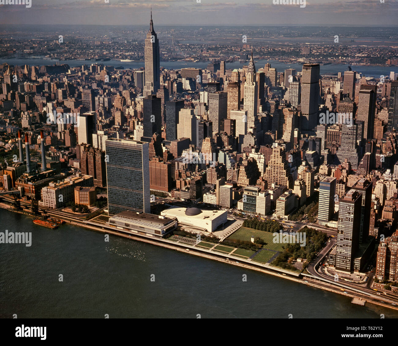1960s AERIAL VIEW EAST RIVER MIDTOWN UNITED NATIONS COMPLEX EMPIRE STATE BUILDING LOOKING WEST TO NEW JERSEY MANHATTAN NYC USA  - kr15769 KRU001 HARS CELEBRATION UNITED STATES SCENIC INSPIRATION UNITED STATES OF AMERICA EMPIRE NY CONFIDENCE NORTH AMERICA NORTH AMERICAN WIDE ANGLE NATIONS TEMPTATION DREAMS MIDTOWN STRUCTURE URBAN CENTER HIGH ANGLE STRENGTH EXTERIOR KNOWLEDGE LEADERSHIP PROGRESS GOTHAM NORTHEAST TRAVEL USA INNOVATION PRIDE TO NYC POLITICS CONCEPTUAL EAST COAST NEW YORK CITIES COMPLEX IMAGINATION STYLISH NEW JERSEY NEW YORK CITY CREATIVITY IDEAS RESORTS AERIAL VIEW BIG APPLE Stock Photo