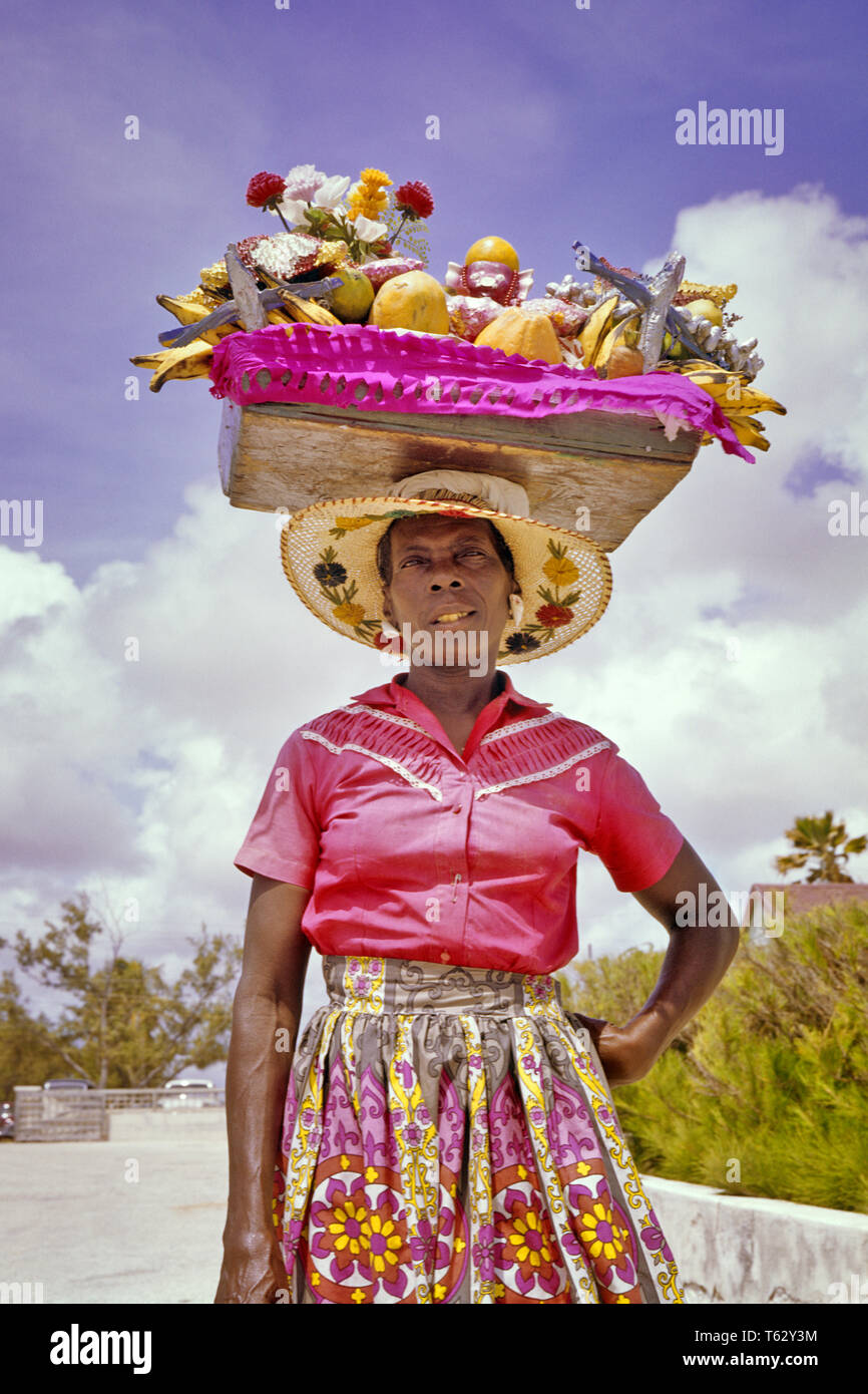 1960s CARIBBEAN WOMAN BARBADOS NATIVE CARRYING BASKET FULL OF FRESH  TROPICAL FRUITS ON HER HEAD - kr6568 LAN001 HARS SELLING ISLANDS  AFRICAN-AMERICANS AFRICAN-AMERICAN LOW ANGLE BLACK ETHNICITY OCCUPATIONS STRAW  HAT BARBADOS LESSER