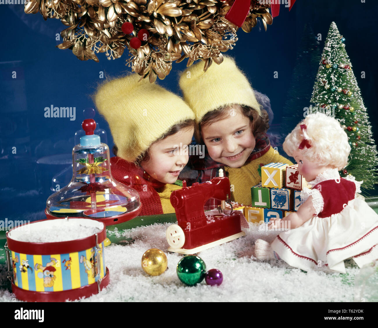 1960s TWO SMILING GIRLS TWIN SISTERS LOOKING IN CHRISTMAS TOY STORE WINDOW AT DOLL AND SEWING MACHINE  - kx5755 HAR001 HARS TWIN IDENTICAL DOUBLE PLEASED JOY LIFESTYLE CELEBRATION FEMALES INSPIRATION MATCH SIBLINGS SISTERS MATCHING SAME DREAMS HAPPINESS HEAD AND SHOULDERS CHEERFUL DISCOVERY STRATEGY CUSTOMER SERVICE MERRY AND CHOICE EXCITEMENT EXTERIOR AT IN ANTICIPATION SIBLING SMILES DECEMBER CONCEPTUAL DECEMBER 25 IMAGINATION JOYFUL SEWING MACHINE STYLISH LOOK-ALIKE DUPLICATE JOYOUS JUVENILES LOOK ALIKE TOGETHERNESS CLONE HAR001 OLD FASHIONED Stock Photo
