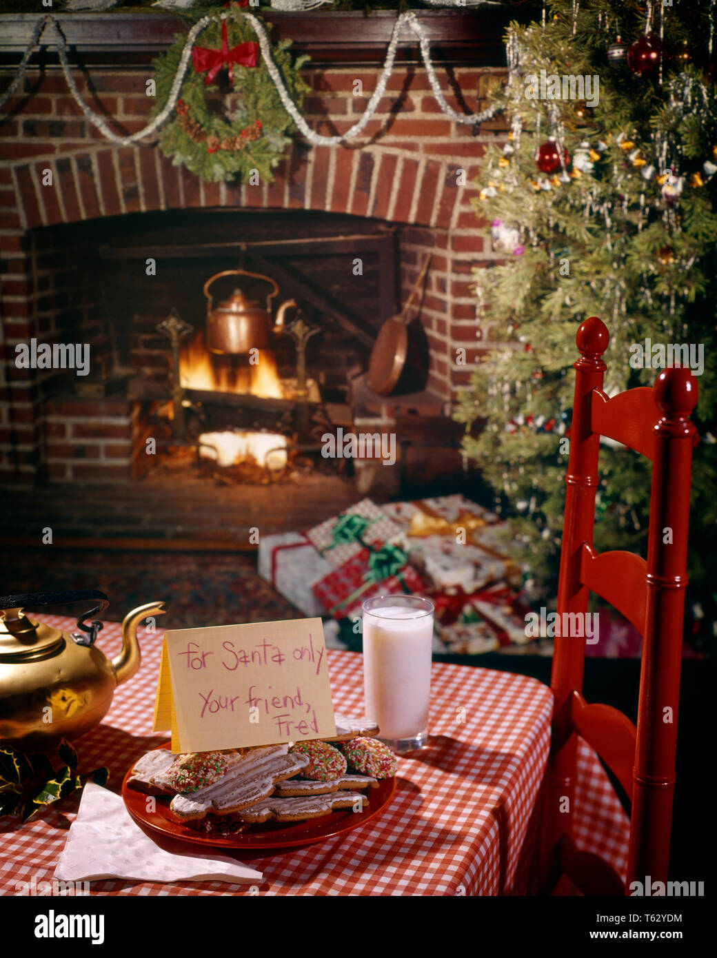 1960s 1970s CHRISTMAS FIREPLACE & TREE TABLE WITH COOKIES GLASS OF MILK AND NOTE FOR SANTA  - kx5980 HAR001 HARS COOPERATION FATHER CHRISTMAS JOLLY JOYOUS NICHOLAS HAR001 OLD FASHIONED Stock Photo