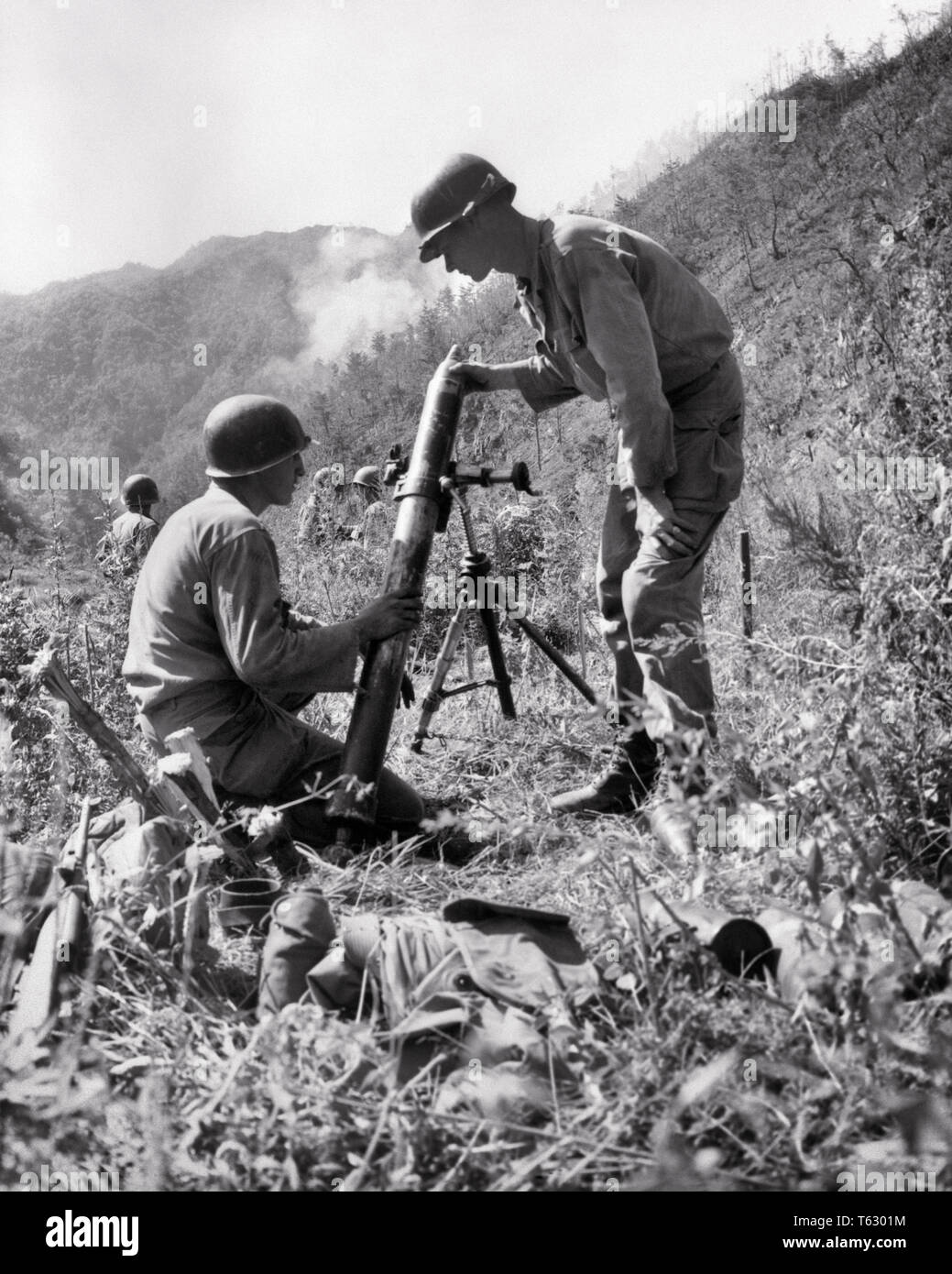 1950s SEPTEMBER 1951 US ARMY 2ND INFANTRY DIVISION SOLDIERS ON HEARTBREAK RIDGE FIRE 81MM MORTAR AT COMMUNIST ENEMY TROOPS KOREA - q74029 CPC001 HARS RURAL COPY SPACE FULL-LENGTH PERSONS MALES RISK CONFIDENCE B&W STRENGTH COURAGE EXCITEMENT ENEMY AT INFANTRYMEN ON FIRING OCCUPATIONS TROOPS UNIFORMS INFANTRYMAN 1951 CONCEPTUAL KOREAN WAR KOREA POLICE ACTION COMMUNIST INFANTRY YOUNG ADULT MAN BLACK AND WHITE CAUCASIAN ETHNICITY OLD FASHIONED SEPTEMBER Stock Photo