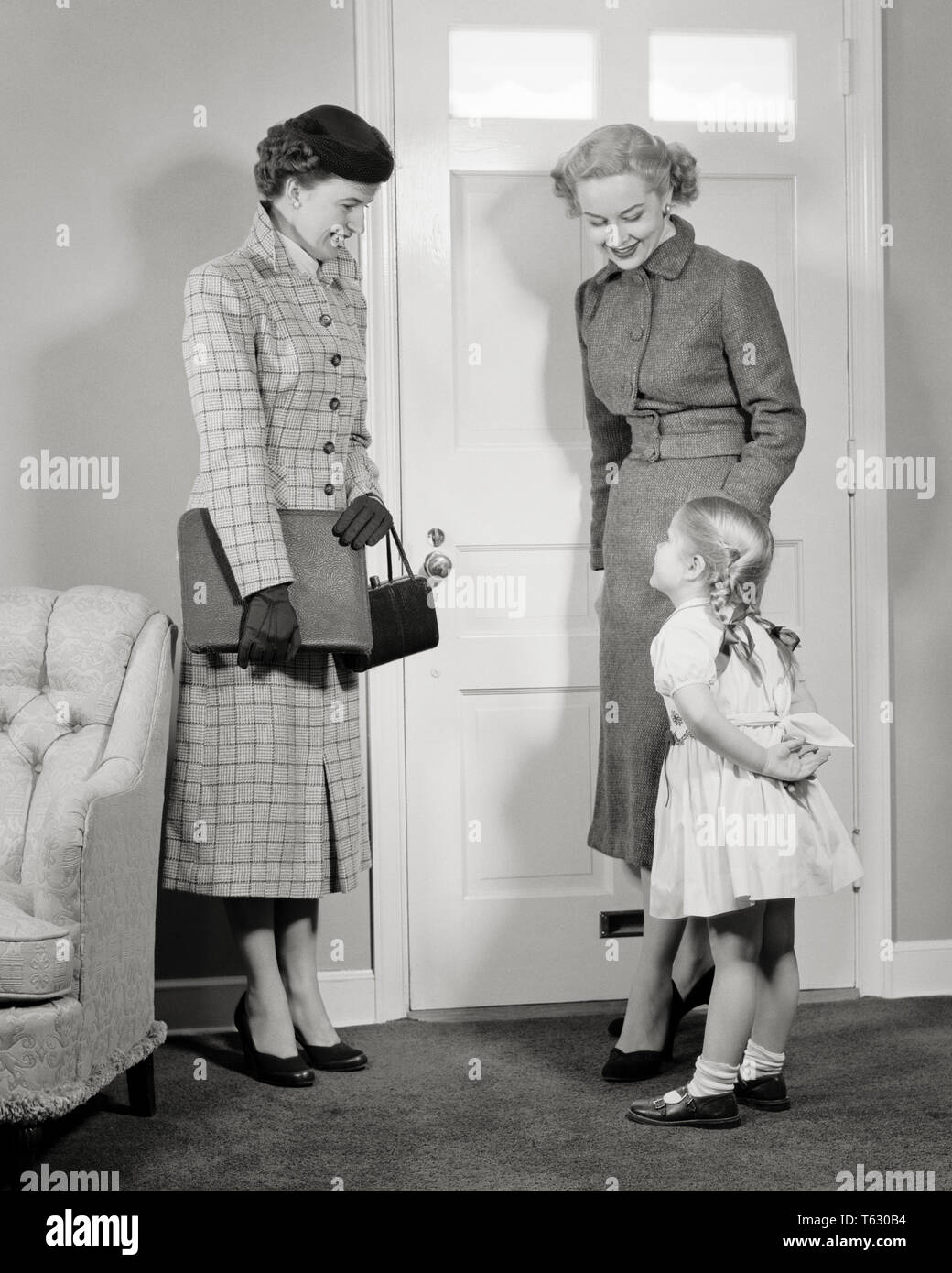 1950s MOTHER AND DAUGHTER  AT DOOR WELCOMING VISITING WOMAN SALESPERSON  - s1030 HAR001 HARS 1 GREETING JUVENILE STYLE WELCOME COMMUNICATION LIFESTYLE SALESPERSON FEMALES HOME LIFE COPY SPACE FULL-LENGTH LADIES DAUGHTERS PERSONS CONFIDENCE B&W BUSINESSWOMAN GREET SELLING HAPPINESS STYLES AND NETWORKING MARY JANE OPPORTUNITY OCCUPATIONS WELCOMING CONNECTION VISITOR INTRODUCTION SALESWOMAN SALESWOMEN STYLISH VISIT VISITING BUSINESSWOMEN BRAIDS COOPERATION FASHIONS JUVENILES MID-ADULT MID-ADULT WOMAN MOMS PIGTAILS TOGETHERNESS BLACK AND WHITE CAUCASIAN ETHNICITY HAR001 OLD FASHIONED Stock Photo