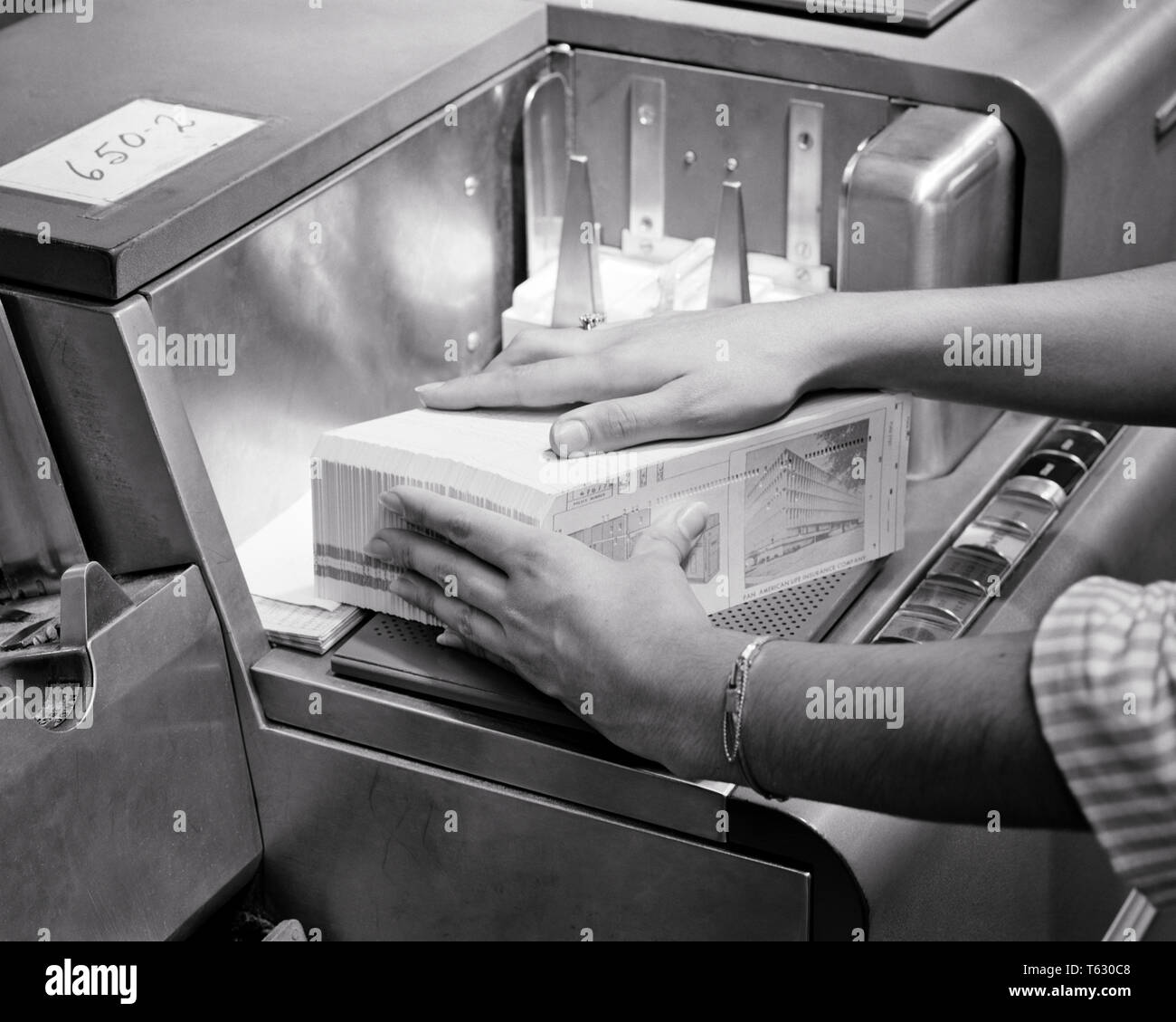 1960s WOMAN’S HANDS LOADING DATA PUNCHED CARDS INTO 20TH CENTURY COMPUTER CARD READER MACHINE - s11208 HAR001 HARS OCCUPATION SKILLS 20TH CENTURY PROGRESS INNOVATION BY INTO OCCUPATIONS HIGH TECH CONCEPTUAL CLOSE-UP HOLES READER INPUT OUTPUT PRECISION PUNCH CARD REPRESENTED BLACK AND WHITE CAUCASIAN ETHNICITY HAR001 OBSOLETE OLD FASHIONED Stock Photo