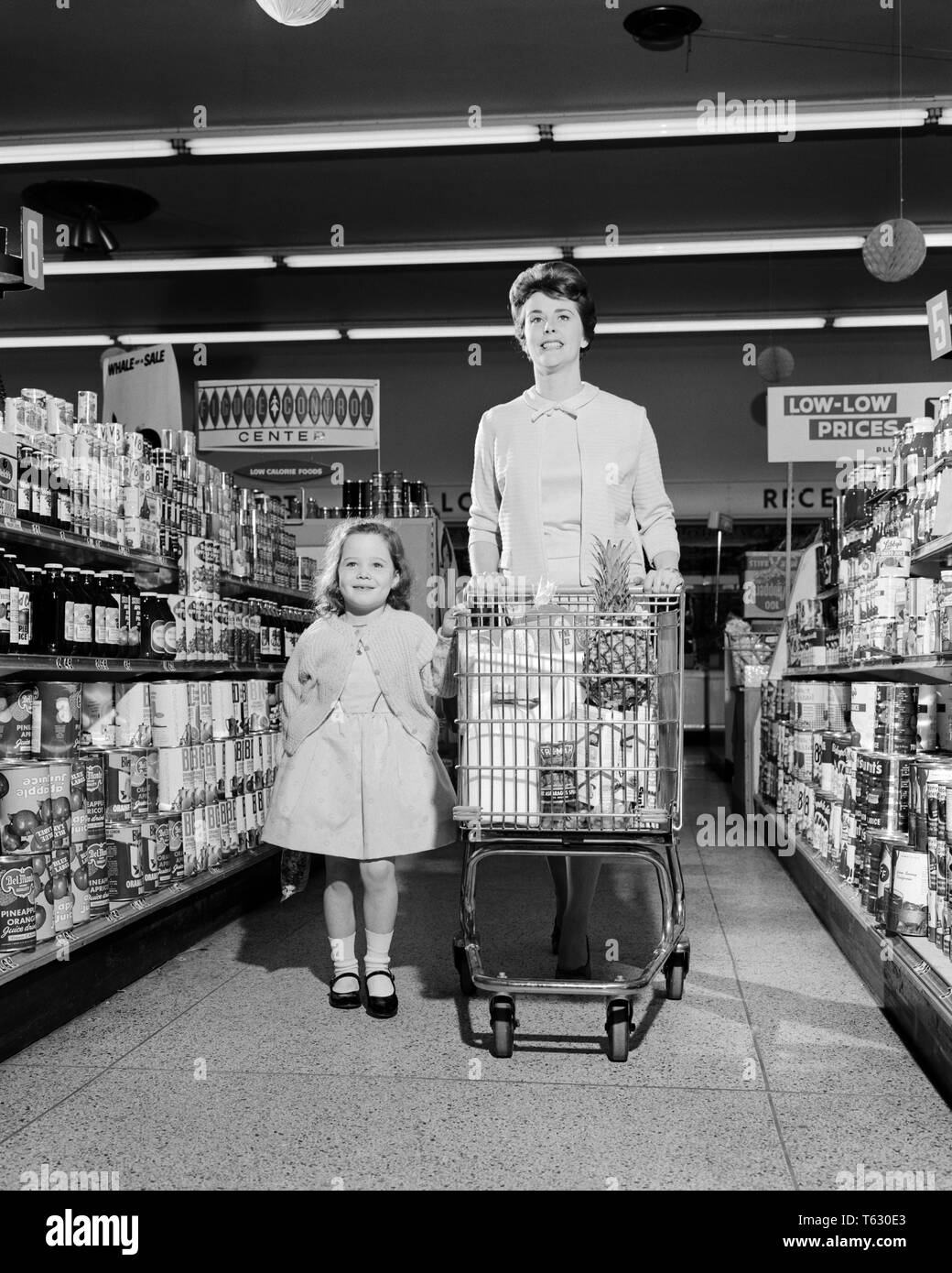 1950s 1960s SMILING MOTHER AND DAUGHTER WALKING DOWN CANNED FOOD AISLE OF SUPERMARKET PUSHING SHOPPING CART - s13082 HAR001 HARS CART GROCERIES MOTHERS OLD TIME BUSY NOSTALGIA OLD FASHION 1 JUVENILE STYLE YOUNG ADULT TEAMWORK PLEASED JOY LIFESTYLE SATISFACTION FEMALES AISLE HEALTHINESS HOME LIFE COPY SPACE FRIENDSHIP FULL-LENGTH LADIES DAUGHTERS PERSONS CONFIDENCE B&W CANNED SHOPPER SHOPPERS HAPPINESS CHEERFUL AND CHOICE KART MARY JANE PRIDE SMILES CONNECTION JOYFUL STYLISH COOPERATION JUVENILES MOMS TOGETHERNESS YOUNG ADULT WOMAN BLACK AND WHITE CAUCASIAN ETHNICITY HAR001 OLD FASHIONED Stock Photo