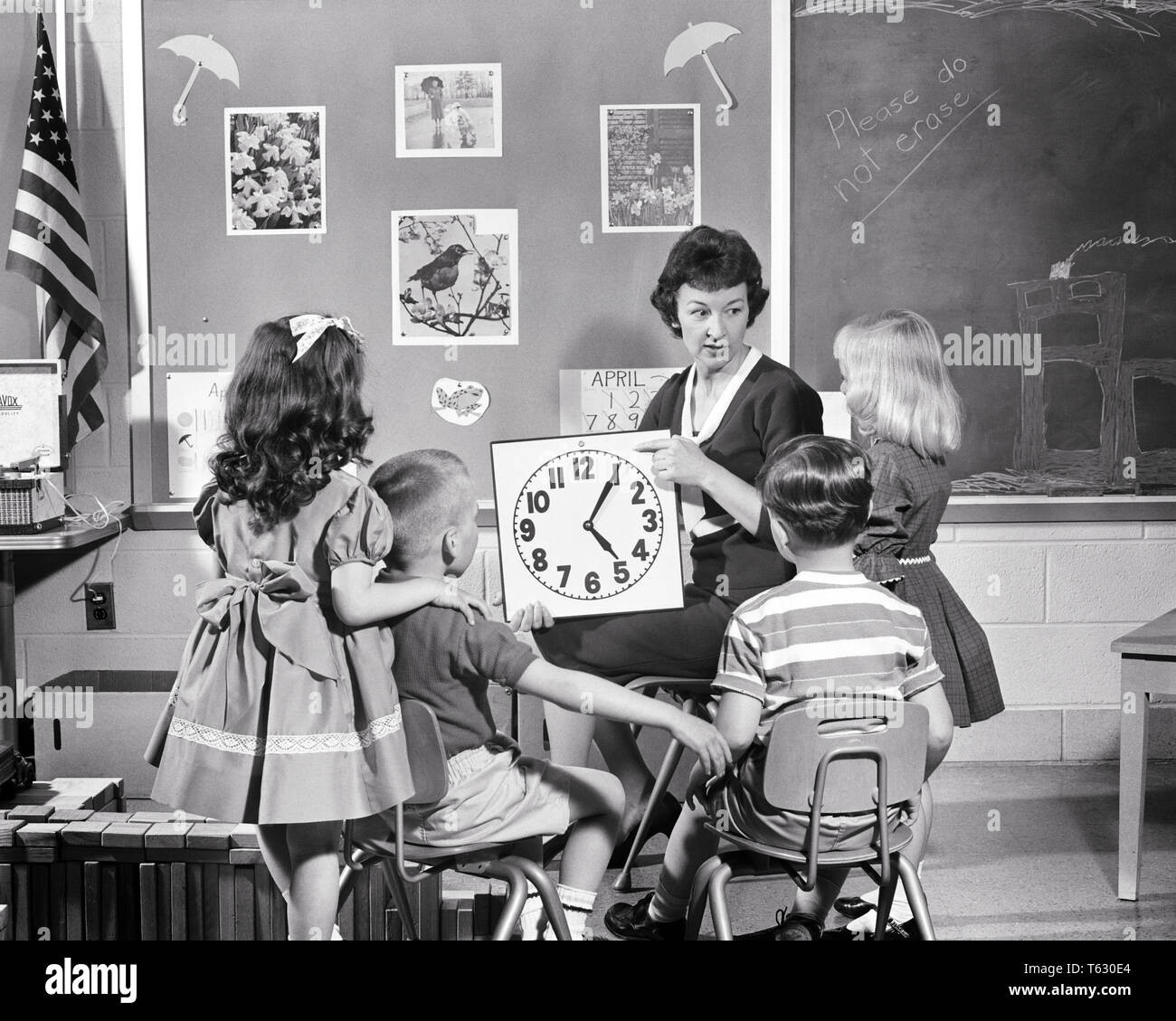 1950s 1960s KINDERGARTEN TEACHER WITH  4 STUDENTS TEACHING THEM HOW TO TELL TIME ON A CLOCK - s13148 HAR001 HARS INFORMATION LIFESTYLE FIVE FEMALES 5 HALF-LENGTH LADIES PERSONS CARING MALES NUMBERS B&W SCHOOLS GRADE KINDERGARTEN HOW INSTRUCTOR KNOWLEDGE HOURS TELLING AUTHORITY OCCUPATIONS PRIMARY MINUTES CONCEPT CONNECTION CONCEPTUAL EDUCATOR TELL K-12 EDUCATING EDUCATORS GRADE SCHOOL INSTRUCTORS JUVENILES MID-ADULT MID-ADULT WOMAN SCHOOL TEACHES TOGETHERNESS BLACK AND WHITE CAUCASIAN ETHNICITY HAR001 OLD FASHIONED Stock Photo