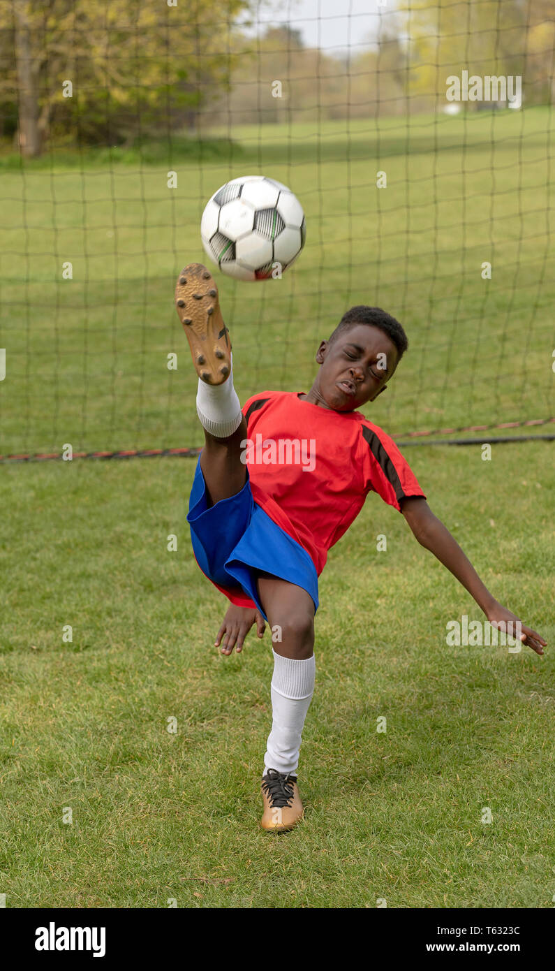 Hampshire, England, UK. April 2019. A young football player defending the goal during a traning session in a public park. Stock Photo