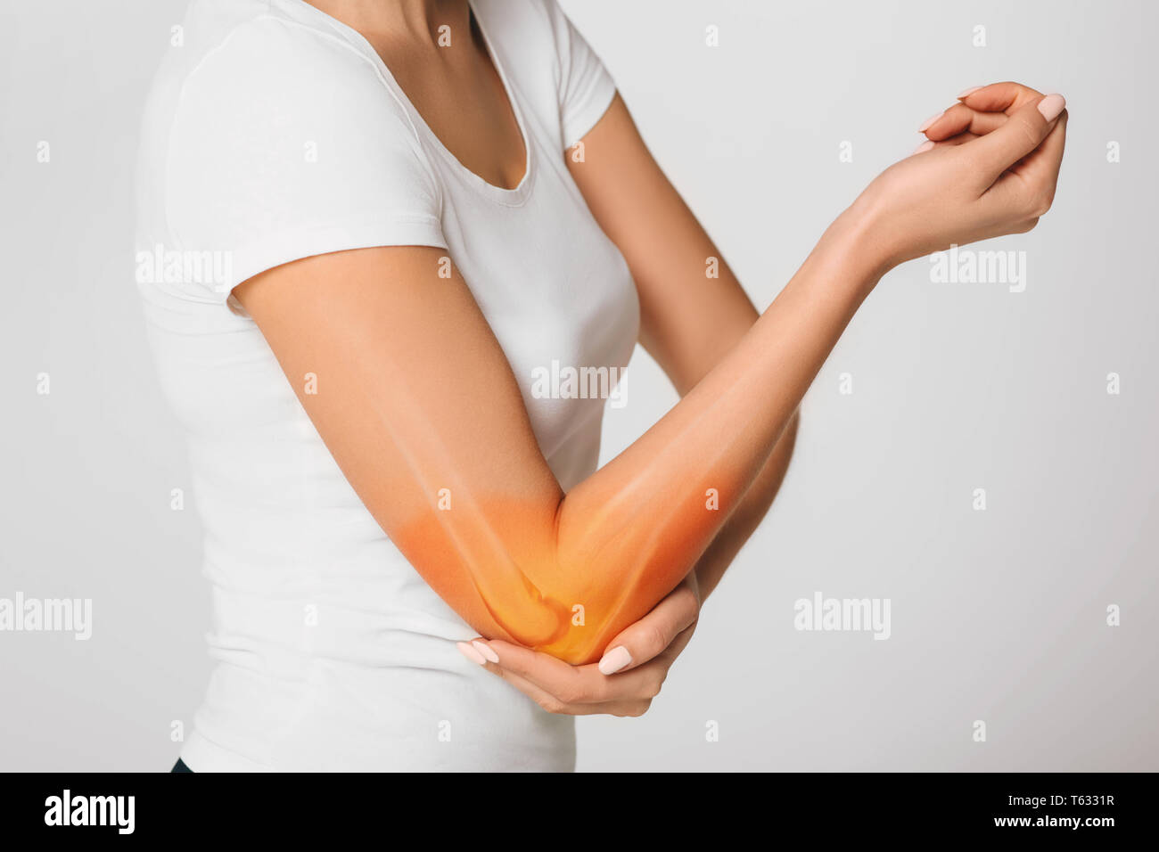 woman suffering pain in the elbow. Composite of image arm bones and elbow Stock Photo