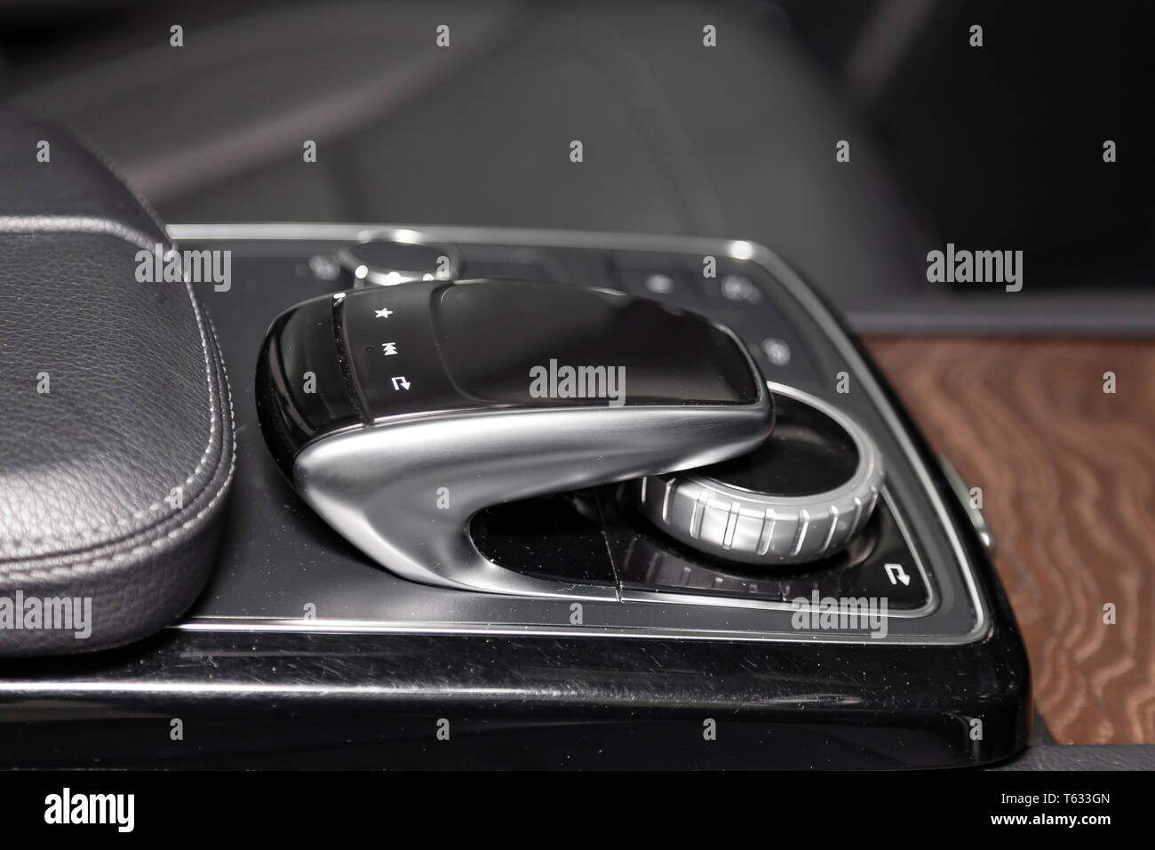 The interior elements of a new expensive business car inside with multimedia system control joystick chrome and aluminum color near black leather armr Stock Photo