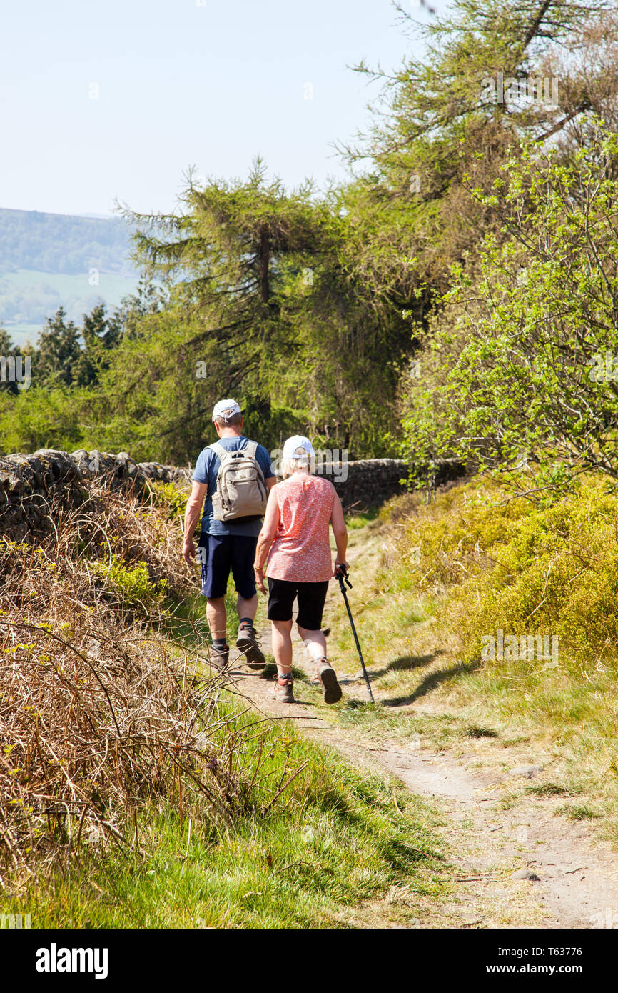 Man and woman couple two people walking along the Nidderdale way a long distance footpath in the Yorkshire Dales in England UK Stock Photo