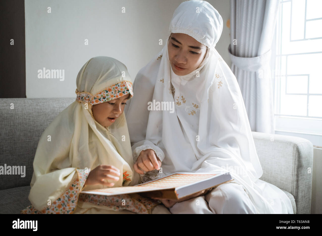 mother and kid reading quran Stock Photo