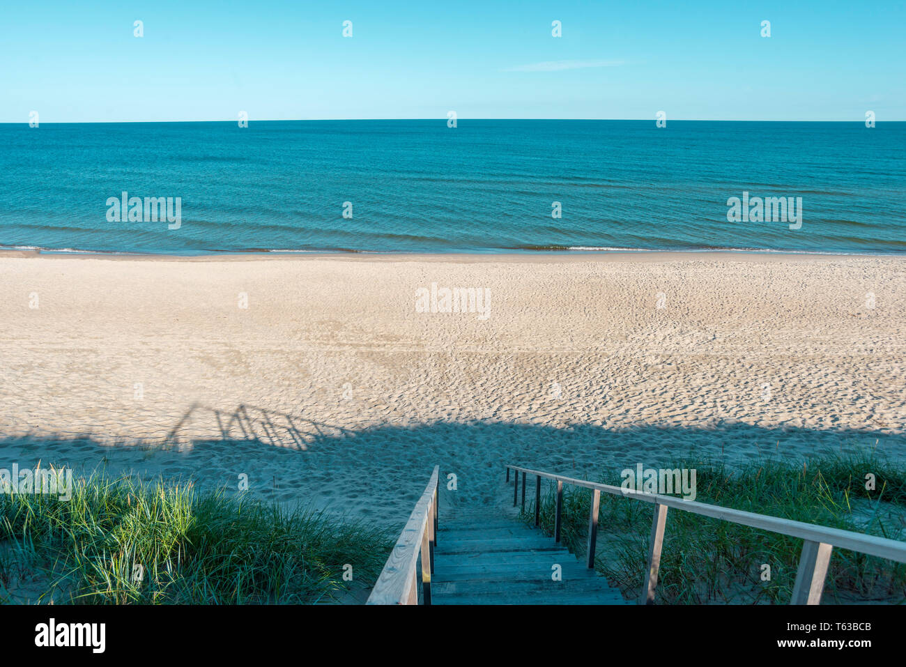 empty beach landscape with wooden stairs going down Stock Photo