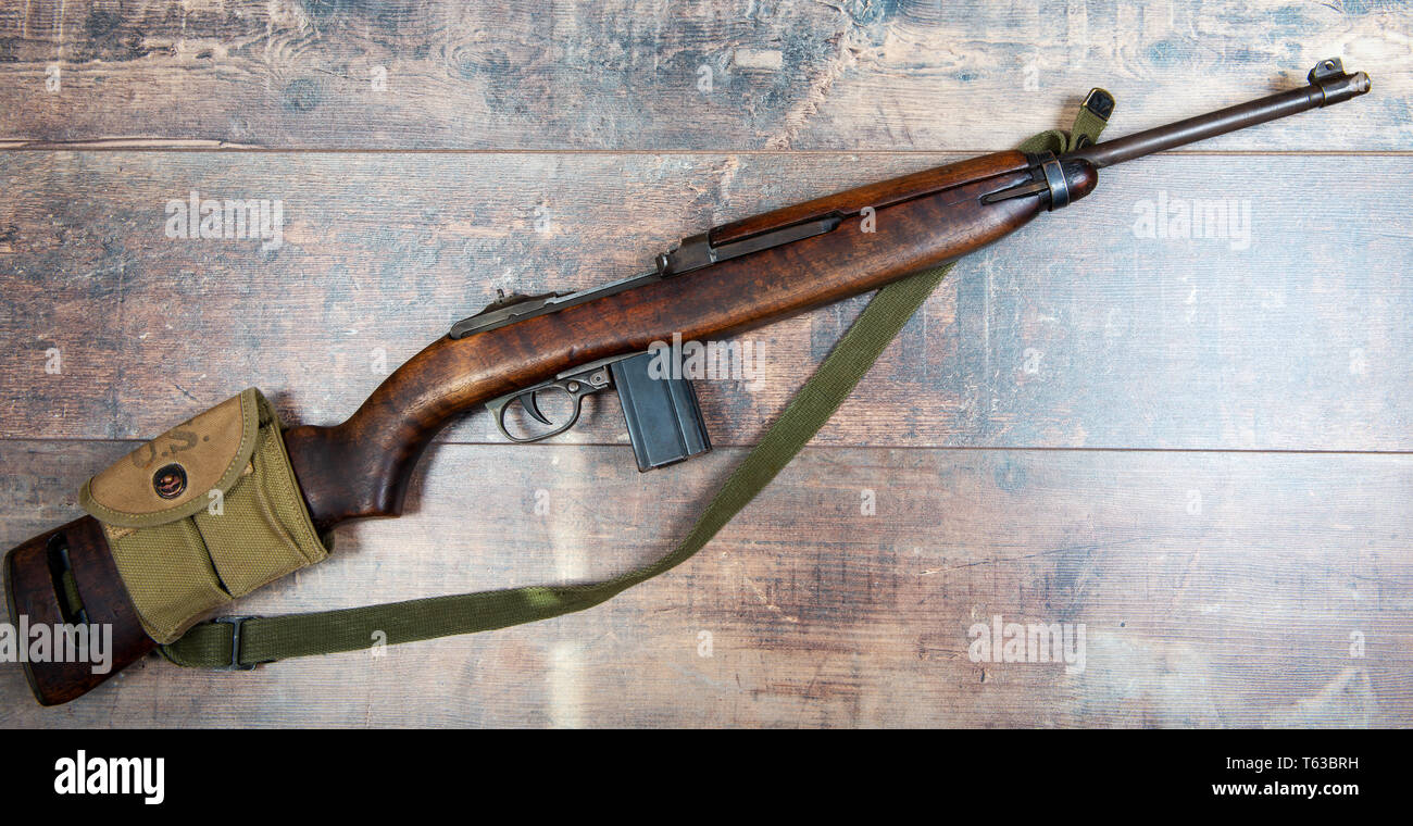a vintage military m1 carbine rifle, with a two clip pouch on the stock