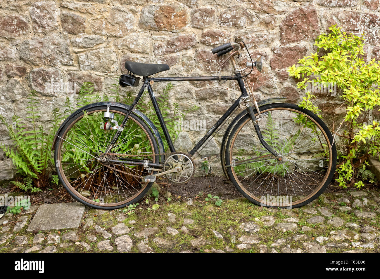 Vintage Raleigh gentleman's bicycle in stone courtyard. Stock Photo