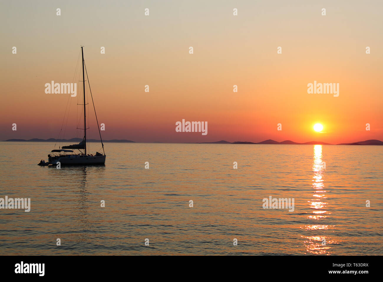 Romantic sunset with silhouette of yacht Stock Photo - Alamy