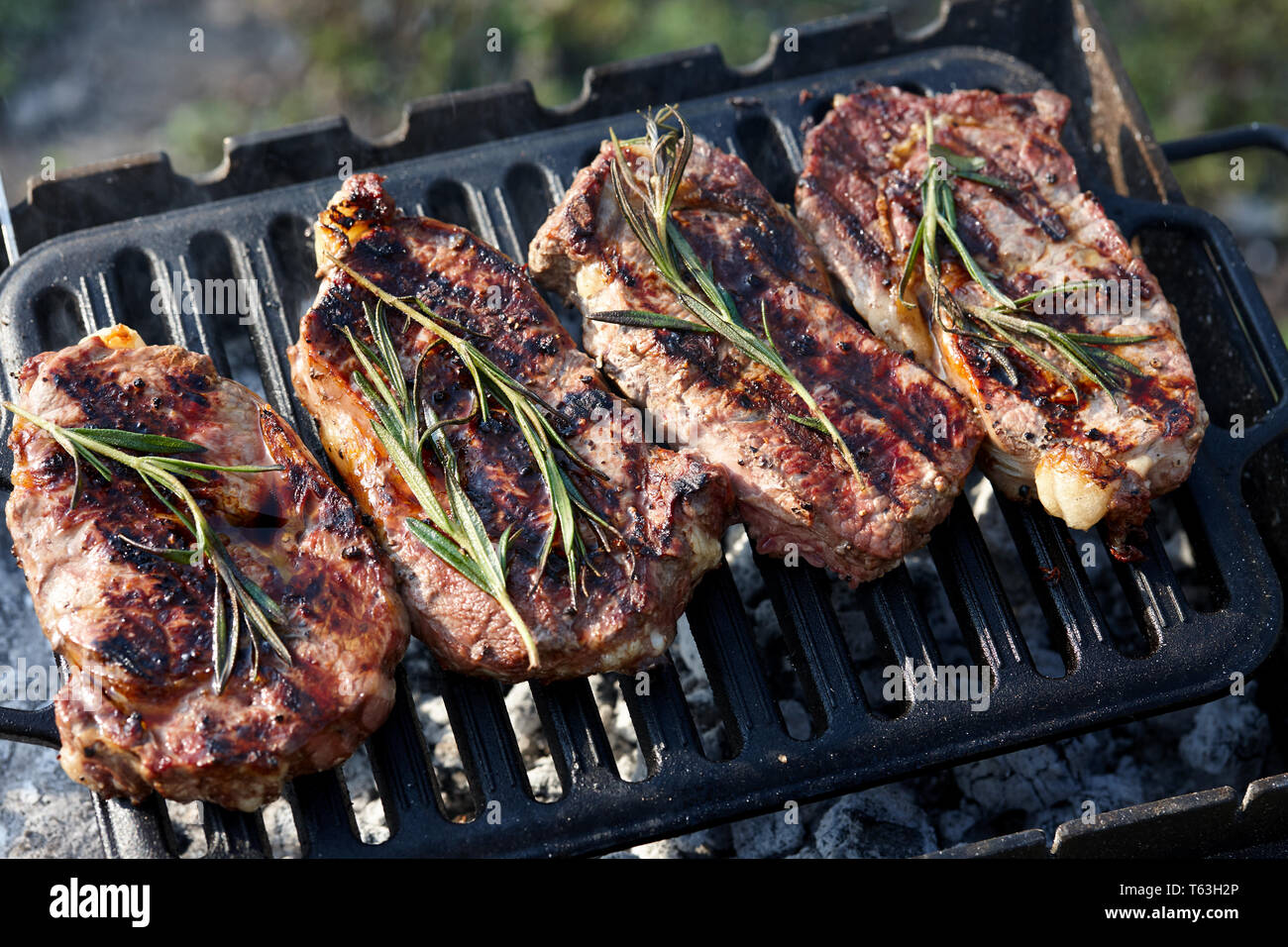 Juicy beef steaks cooking on grill outdoors Stock Photo Alamy