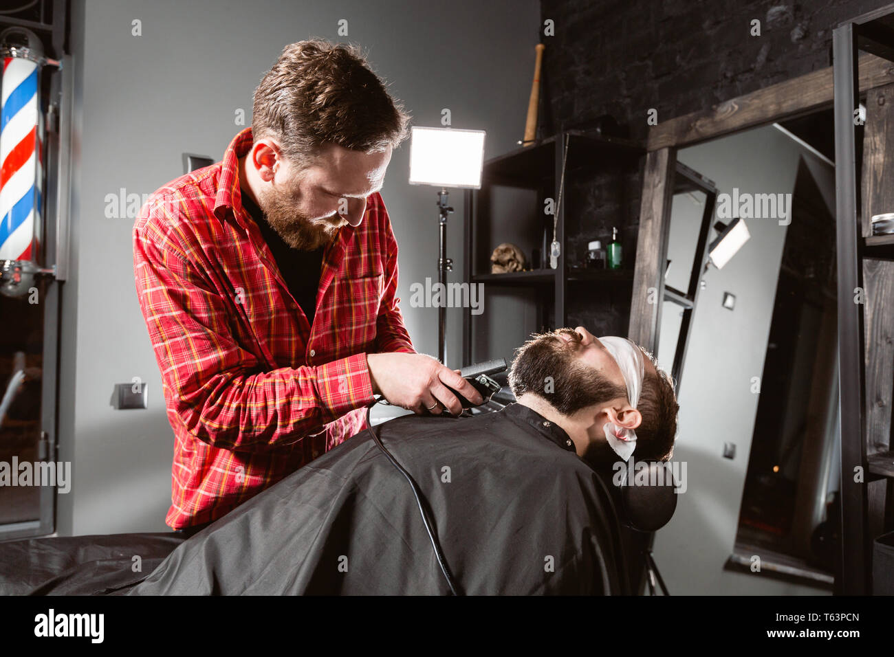 Barber work with clipper machine in barbershop. Professional trimmer ...