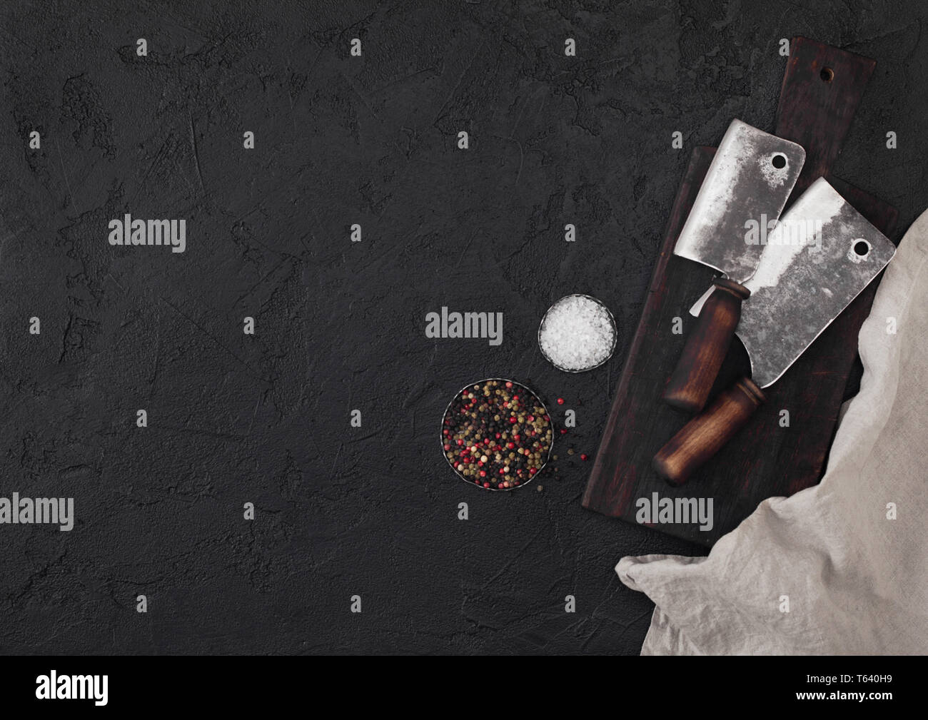 Vintage meat knife hatchet on vintage chopping board and black stone