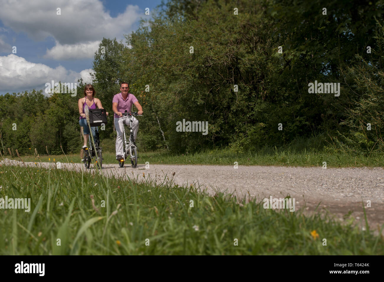 Young happy couple cycling in the nature on modern e-bikes Stock Photo