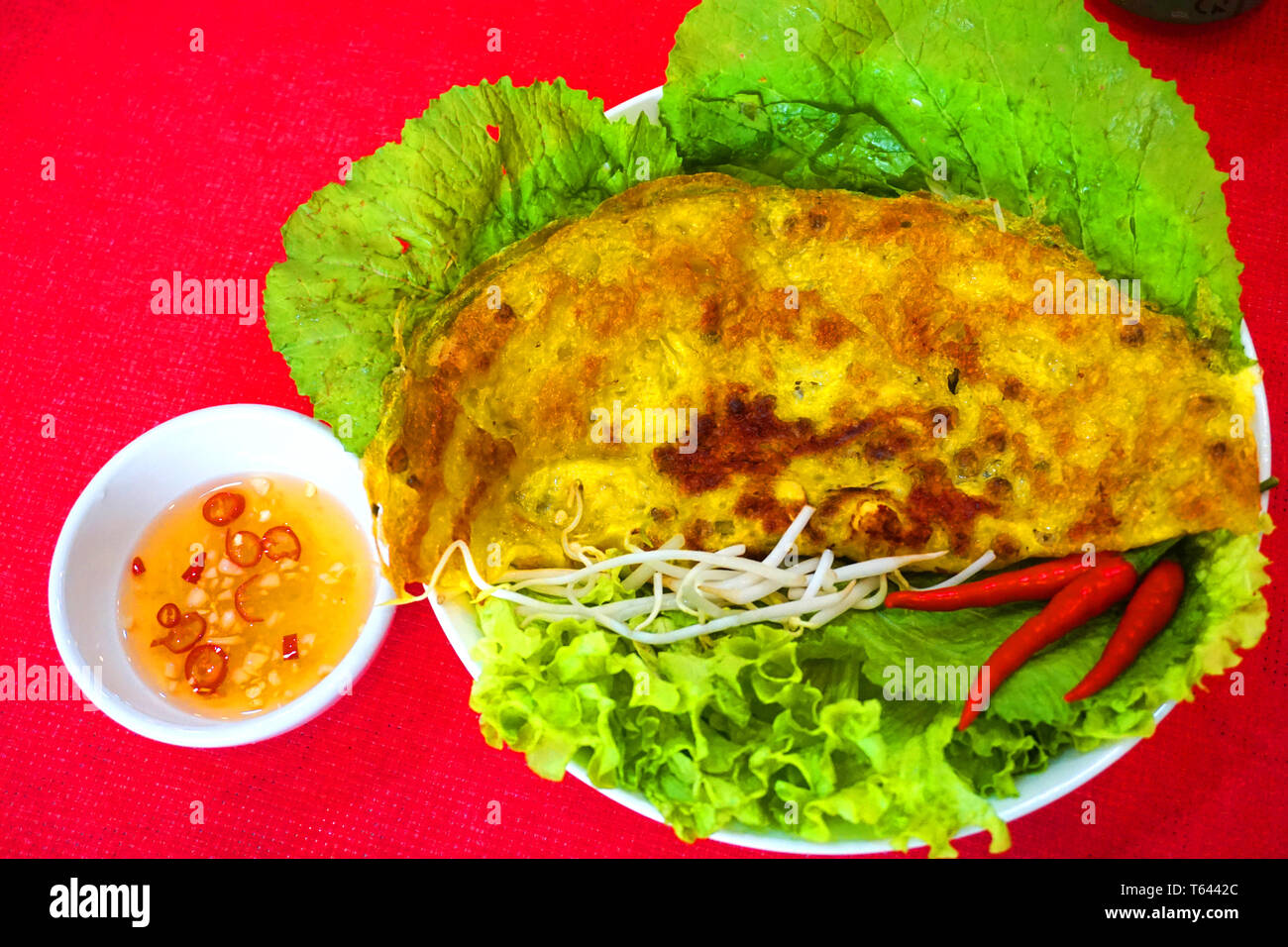 Banh xeo - Vietnamese traditional street food yellow crispy rice flour cake with mushroom shrimp mung bean sprout sizzling cake with fish sauce chilli Stock Photo