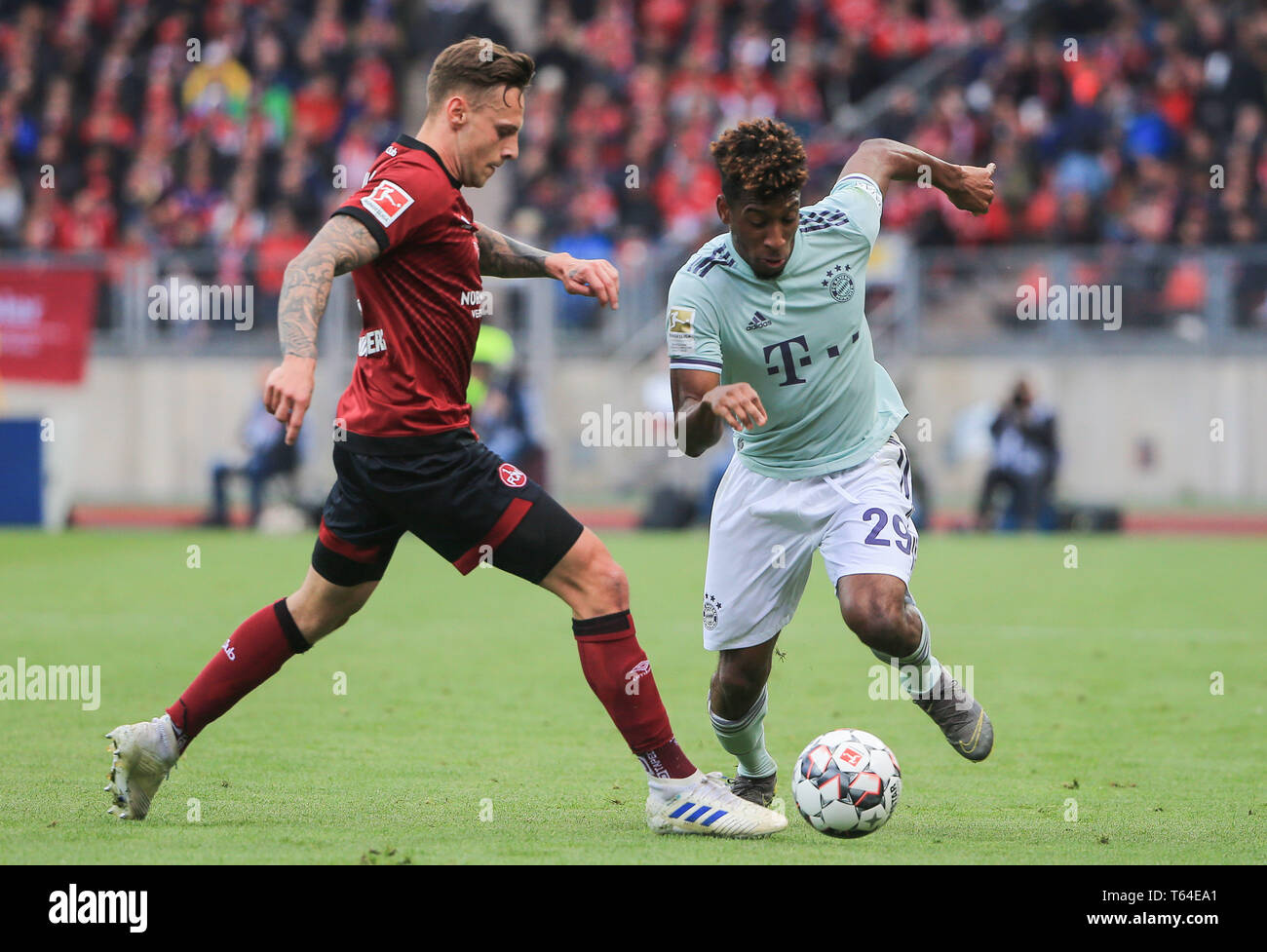 Nuremberg, Germany. 28th Apr, 2019. Bayern Munich's Kingsley Coman (R) vies with Nuremberg's Robert Bauer during a German Bundesliga match between 1.FC Nuremberg and FC Bayern Munich in Nuremberg, Germany, on April 28, 2019. The match ended 1-1. Credit: Philippe Ruiz/Xinhua/Alamy Live News Stock Photo