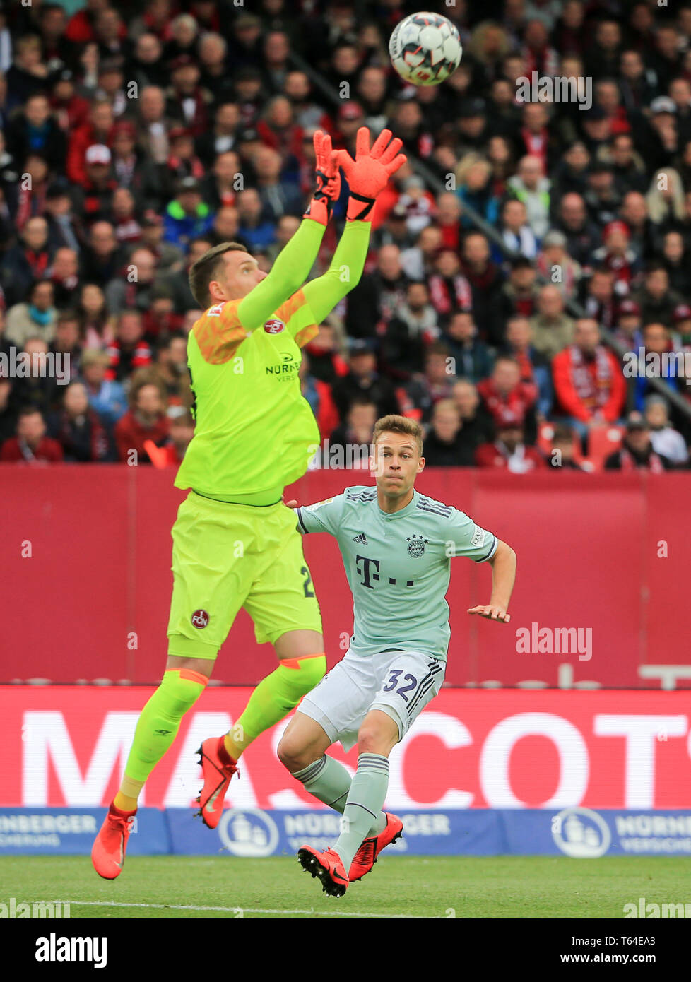 Nuremberg, Germany. 28th Apr, 2019. Bayern Munich's Joshua Kimmich (R) and Nuremberg's Christian Mathenia compete during a German Bundesliga match between 1.FC Nuremberg and FC Bayern Munich in Nuremberg, Germany, on April 28, 2019. The match ended 1-1. Credit: Philippe Ruiz/Xinhua/Alamy Live News Stock Photo