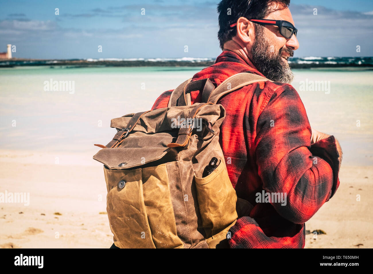Travel and backpack wanderlust concept people with adult hipster man with beard and sunglasses enjoying the outdoor leisure activity with beach and be Stock Photo