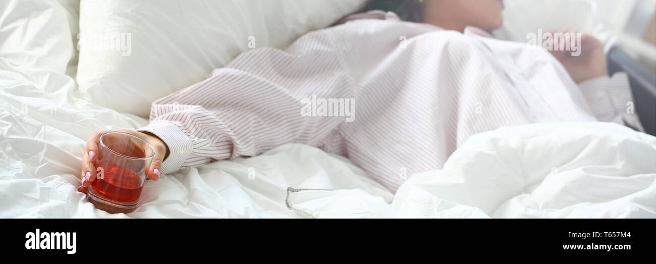 Young woman lying in bed deadly drunken Stock Photo