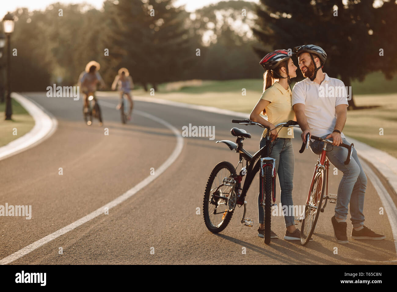 Happy couple is kissing on the bicycles. Stock Photo