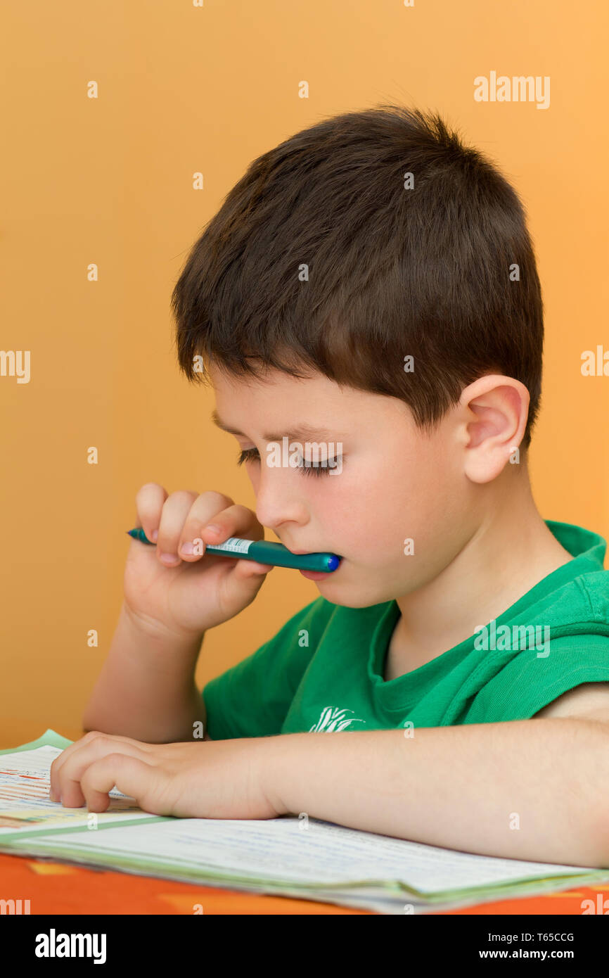 boy doing homework from school in workbook Stock Photo