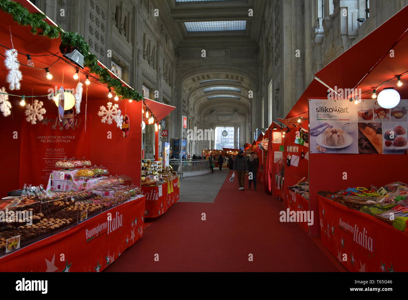 Milan/Italy - January 15, 2014: Traditional Italian Christmas market stalls decorated with the red fabric and red carpet inside the Central station. Stock Photo
