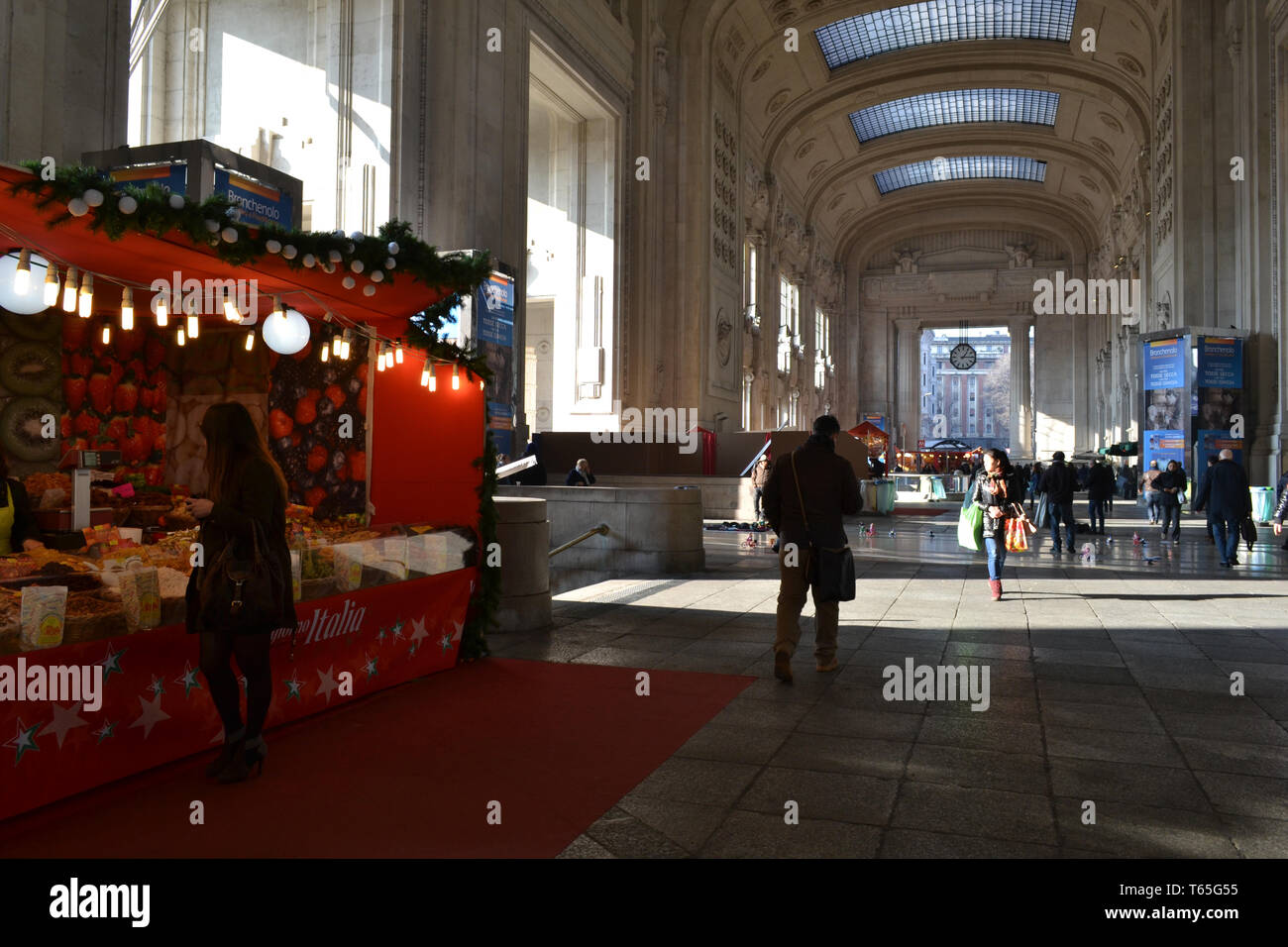 Milan/Italy - January 15, 2014: Traditional Italian Christmas market stalls decorated with the red fabric and red carpet inside the Central station. Stock Photo