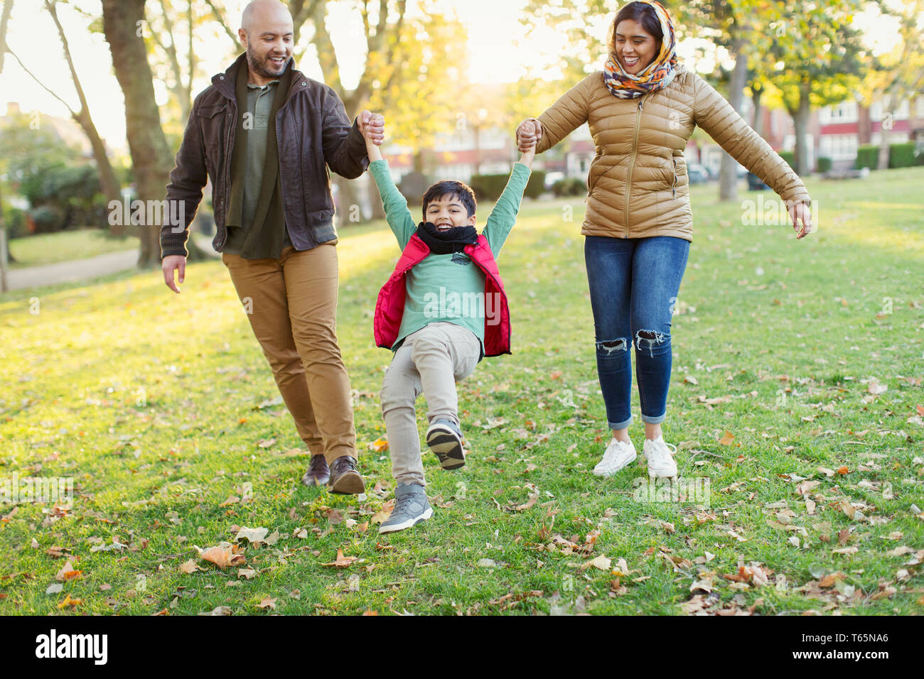 Playful Muslim family in autumn park Stock Photo