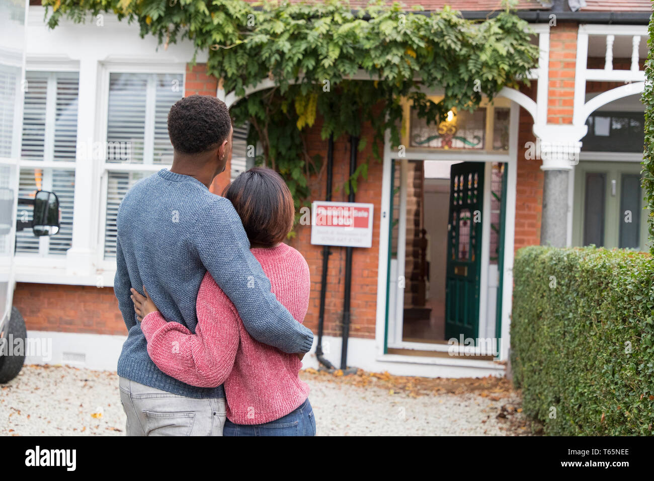 Happy, affectionate couple hugging outside new house Stock Photo