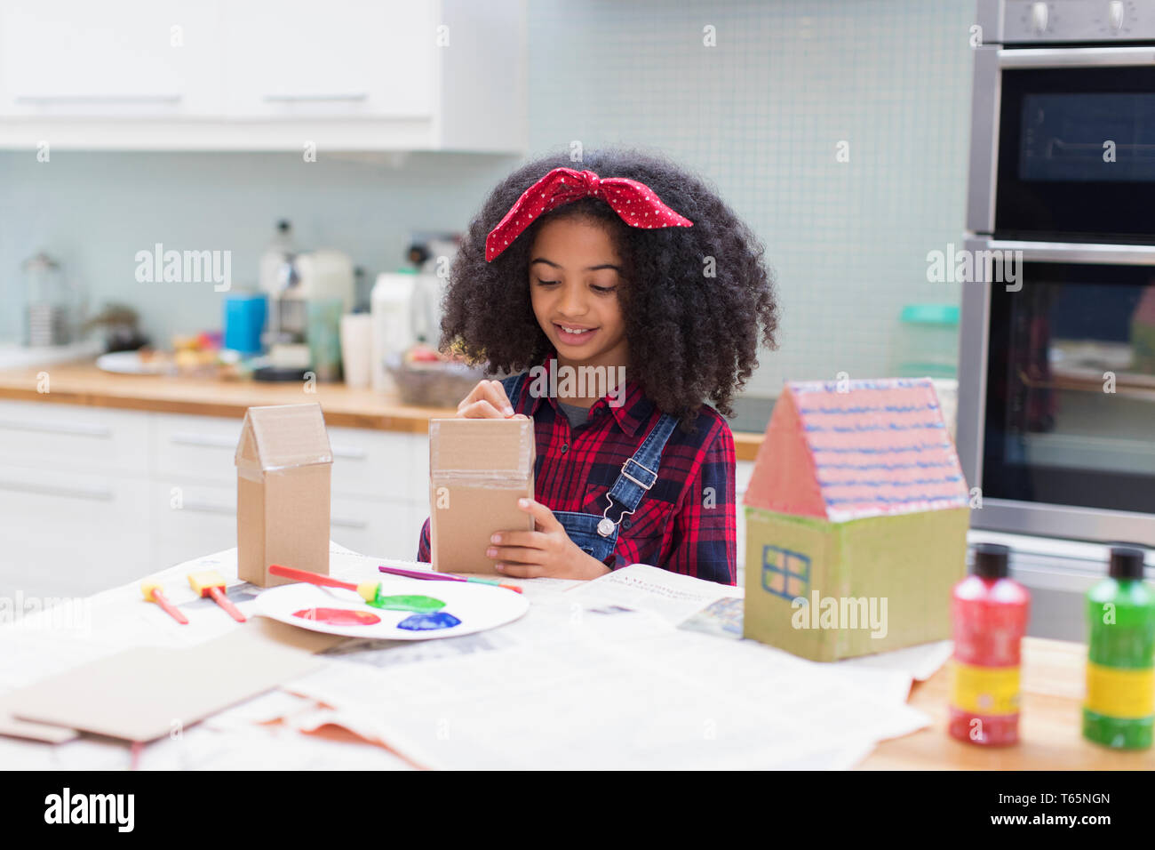 Girl painting house crafts in kitchen Stock Photo