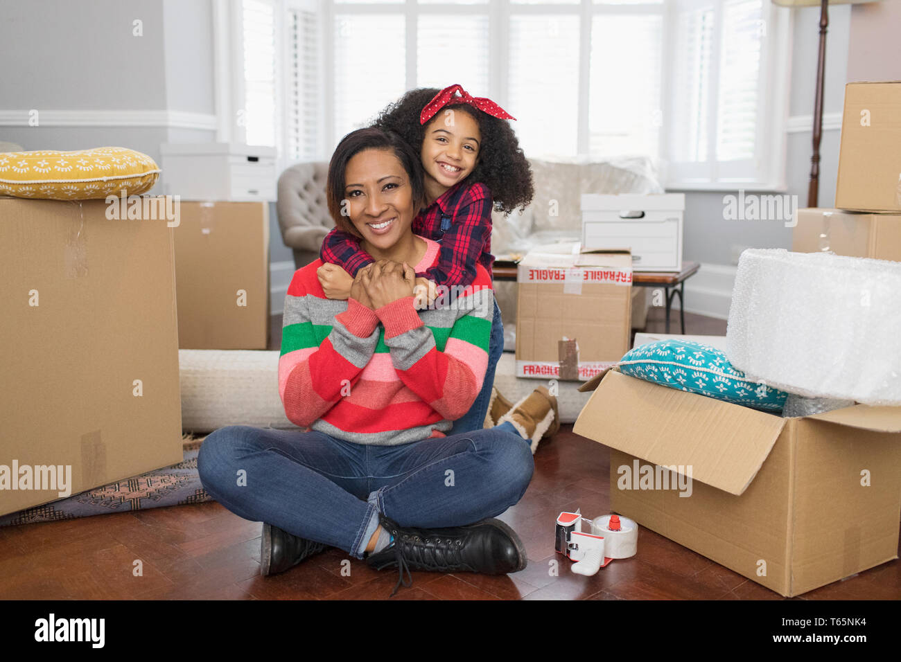 Portrait happy mother and daughter hugging, moving into new house Stock Photo