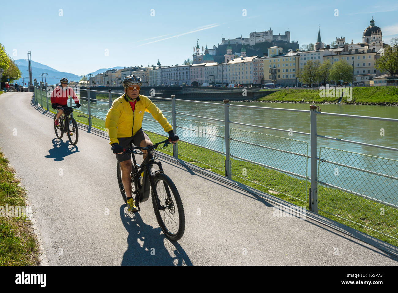 Cycling Austria, view on a summer morning of a middle-aged couple cycling on a cycle path alongside the River Salzach in Salzburg, Austria. Stock Photo